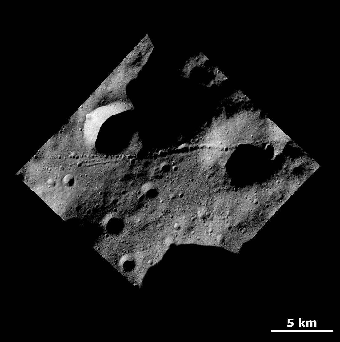 This image from NASA's Dawn spacecraft shows a surface with many craters and linear chains of small craters that merge into ridges on the giant asteroid Vesta.