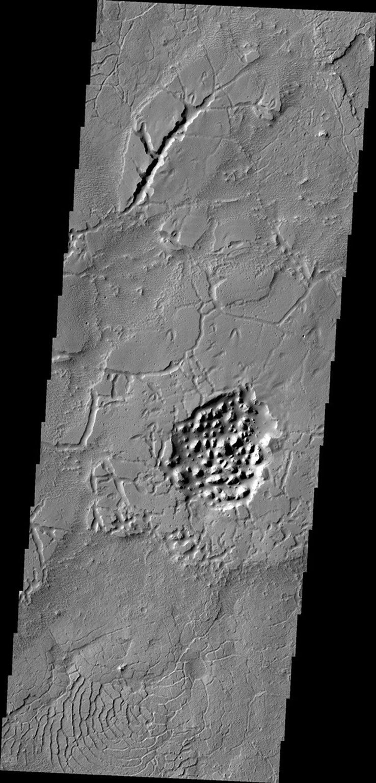 The Avernus region contains several different surface features. These include tectonic fractures, ridges, hills, and regions of chaos within isolated depressions termed cavi. This image was captured by NASA's 2001 Mars Odyssey spacecraft.