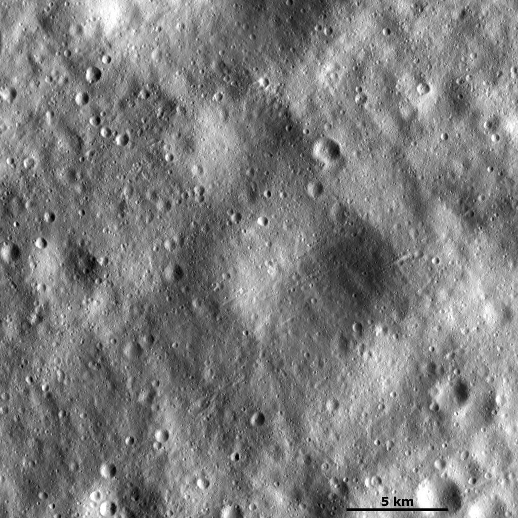 This image from NASA's Dawn spacecraft shows many large subdued craters that have smaller, younger craters on top of them on asteroid Vesta. There are two large subdued craters in the center of the image, which have very degraded and rounded rims.
