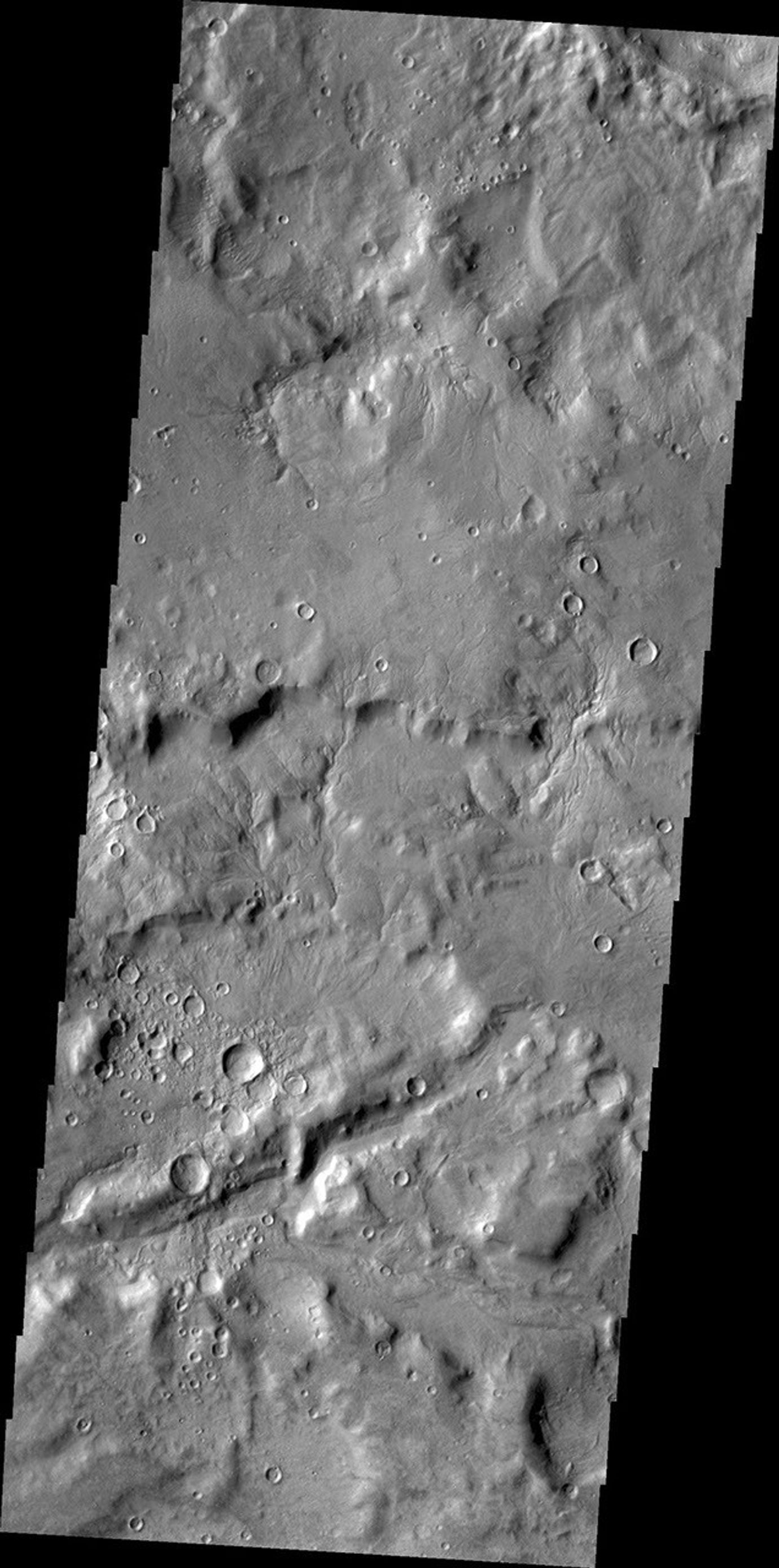 Small channels dissect the inner rim of this unnamed crater in Arabia Terra as seen by NASA's 2001 Mars Odyssey spacecraft.