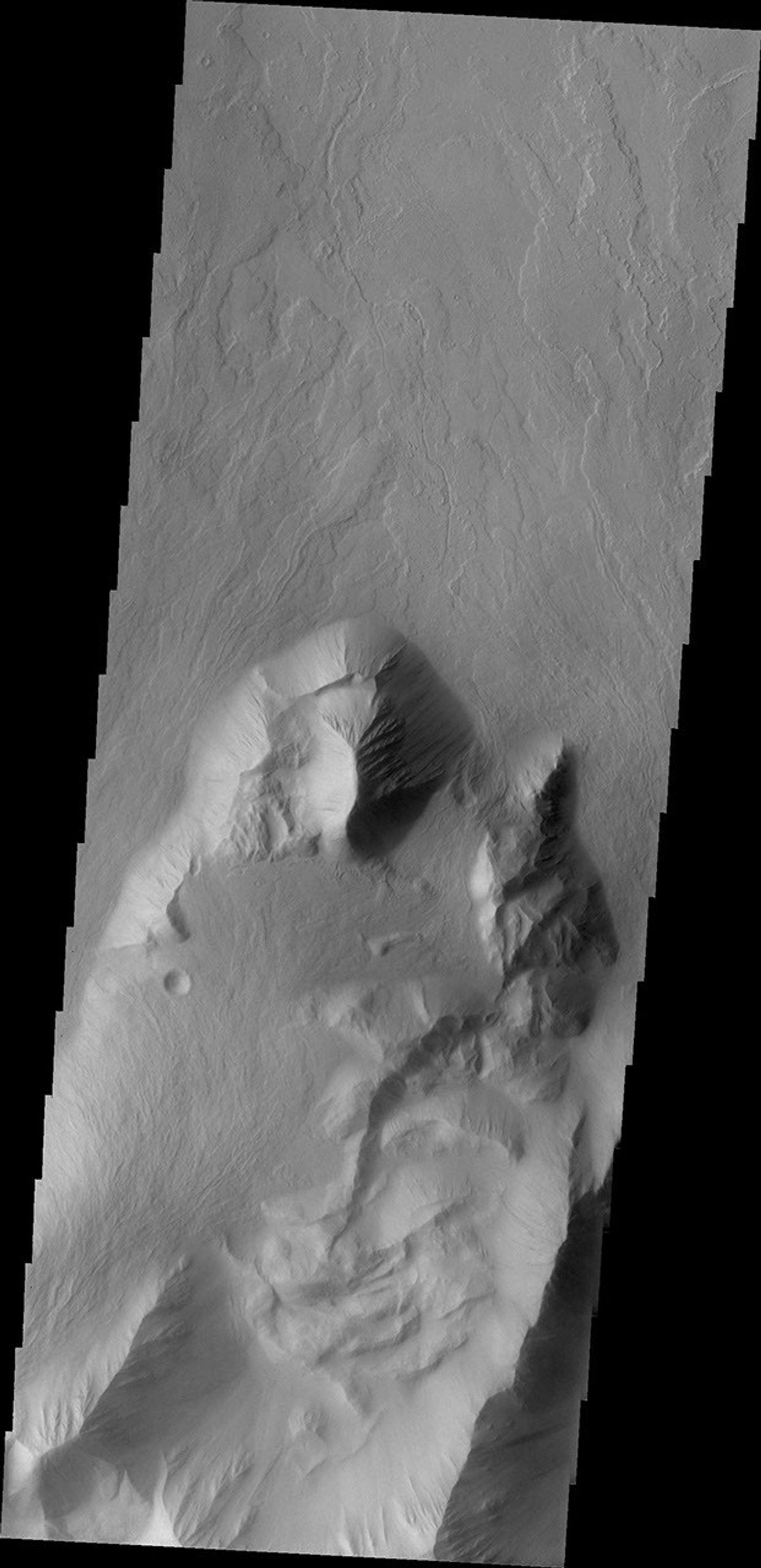 This image from NASA's 2001 Mars Odyssey spacecraft shows lava flows which have plunged over the steep escarpment marking the edge of Olympus Mons into the surrounding plains.