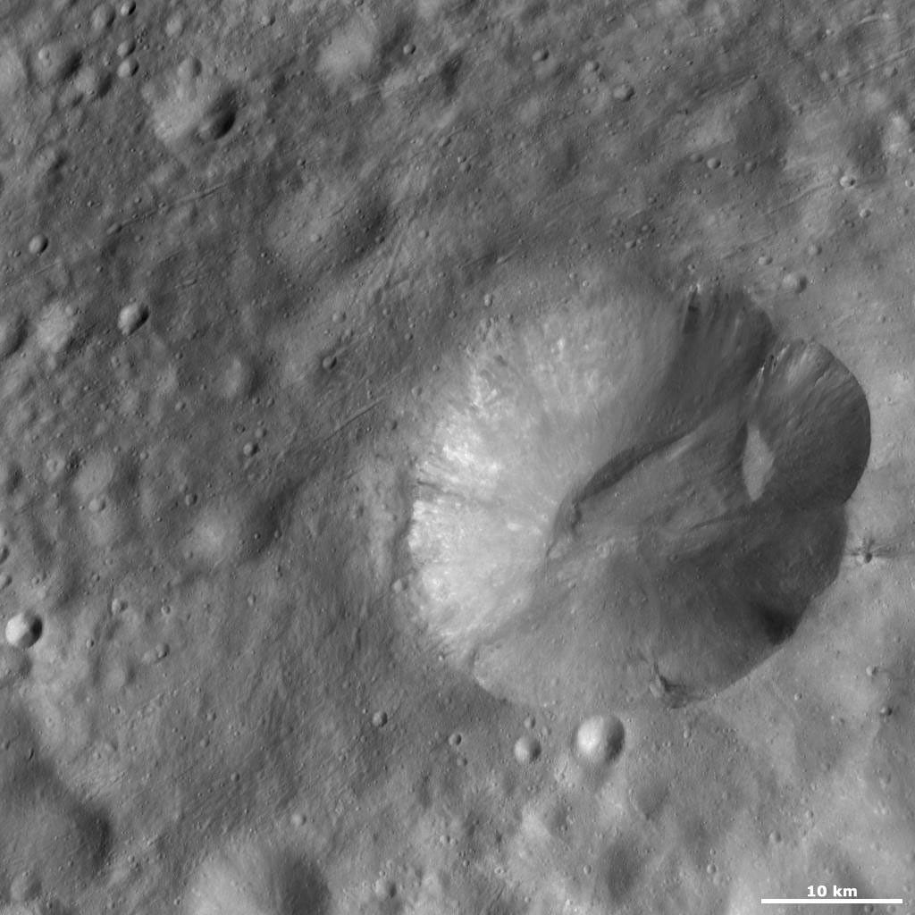 This image from NASA's Dawn spacecraft is located in Marcia quadrangle, just south of Vesta's equator. It has a scalloped shaped rim and the top part of the rim is more degraded than the rest.