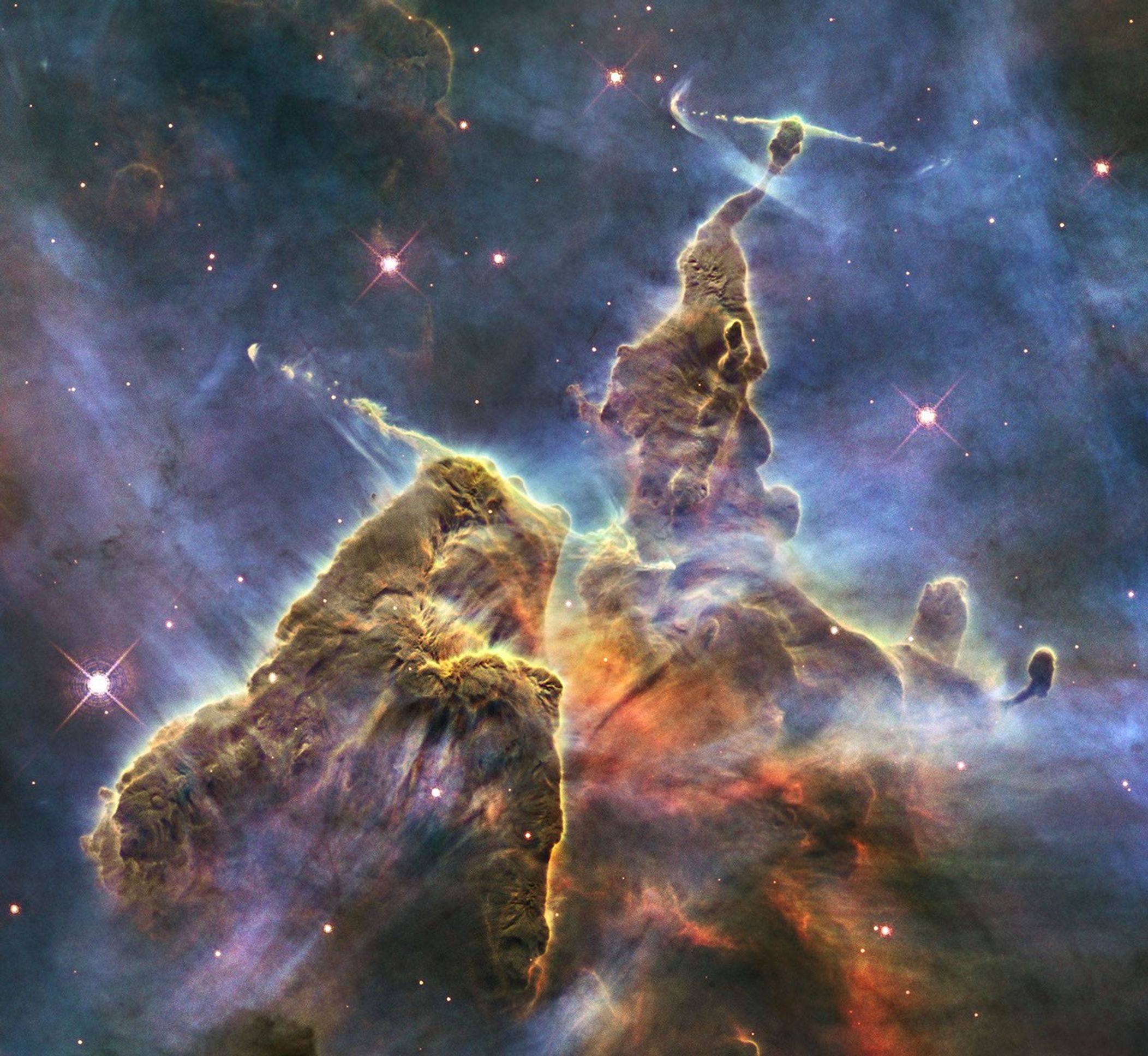 NASA's Hubble Space Telescope captures the chaotic activity atop a three-light-year-tall pillar of gas and dust that is being eaten away by the brilliant light from nearby bright stars in a tempestuous stellar nursery called the Carina Nebula.