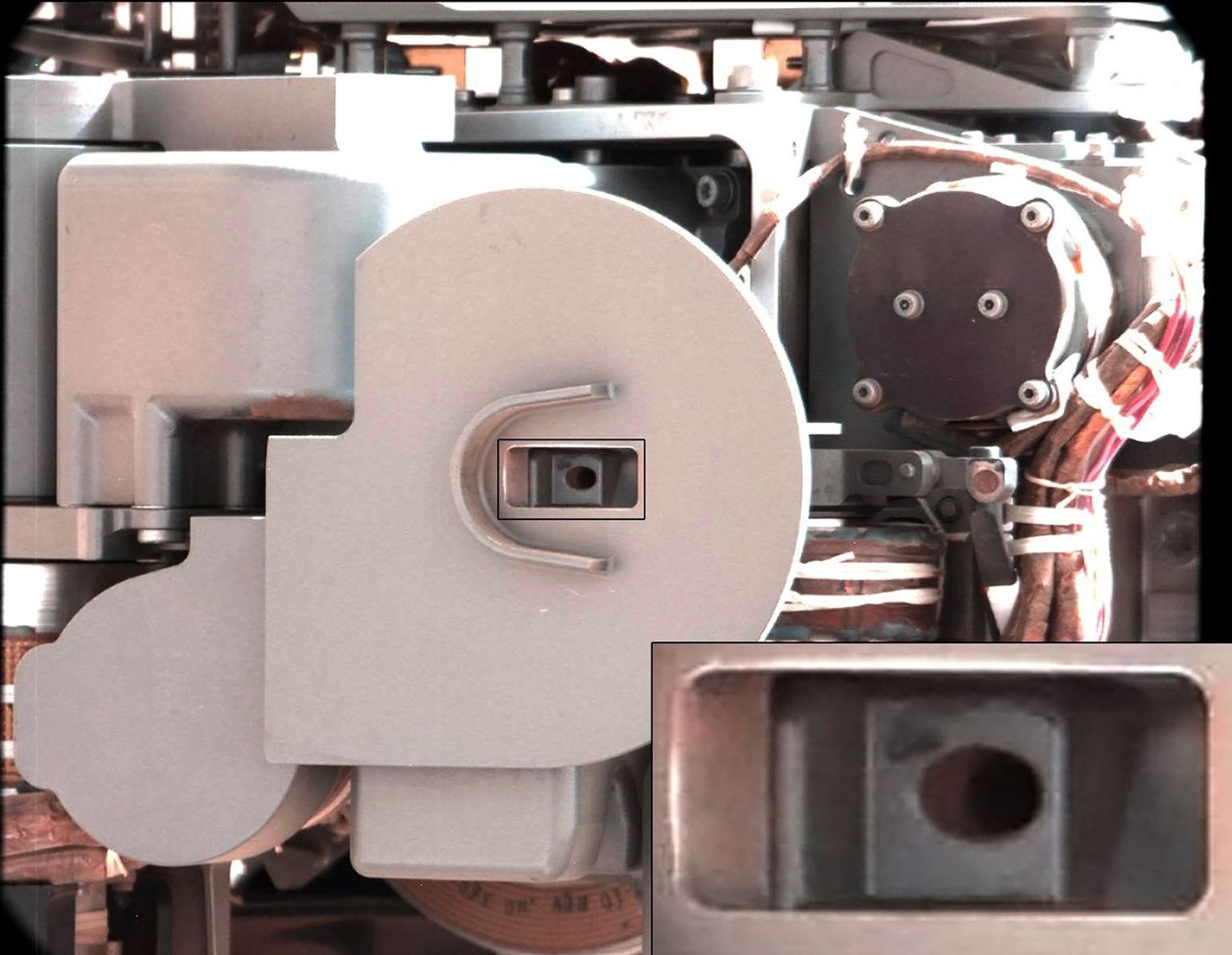 This image from NASA's Curiosity rover just after discarding a soil sample as part of its first 'decontamination' exercise. A small amount of remnant material is visible inside the delivery tube, which is magnified in the blow-up at lower right.