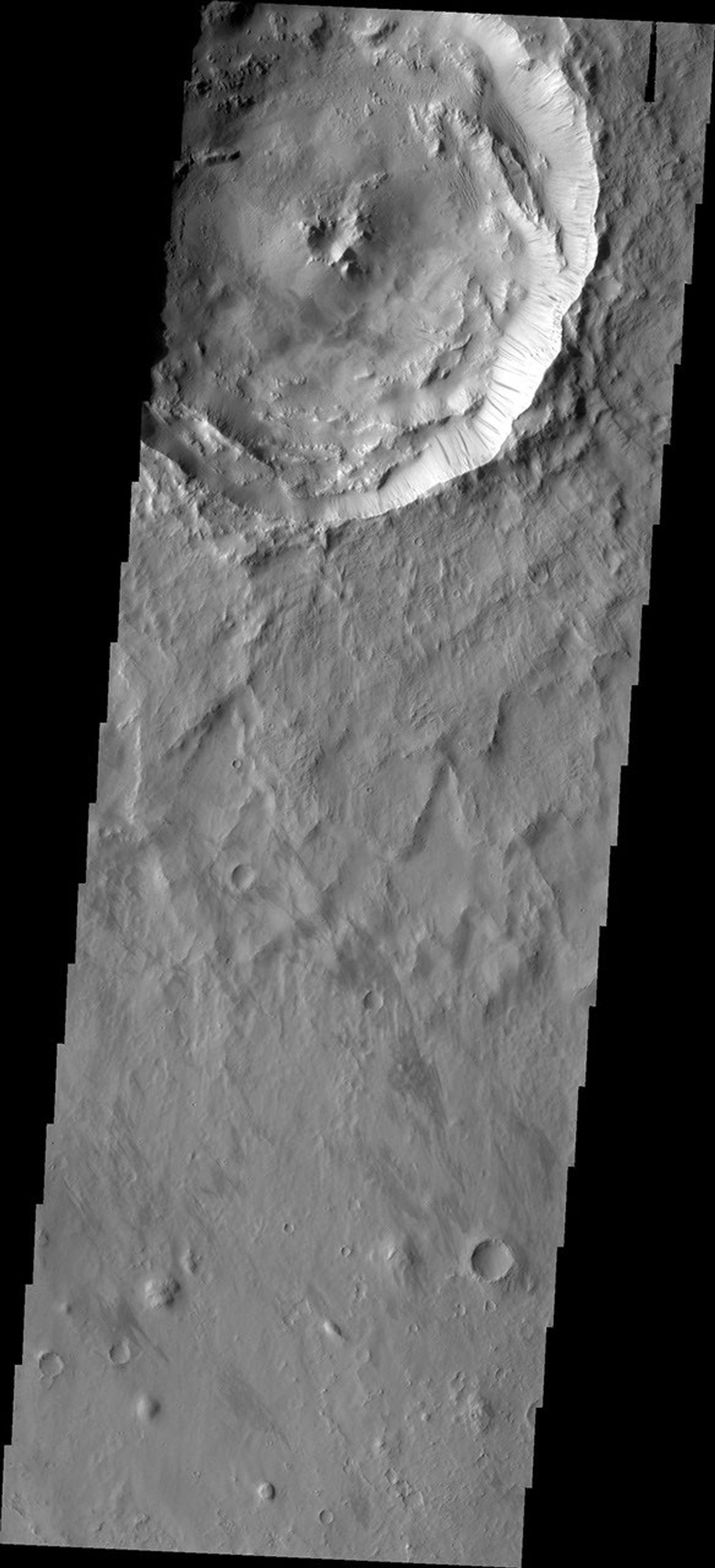 Dark slope streaks mark the rim of this unnamed crater as seen by NASA's 2001 Mars Odyssey spacecraft.
