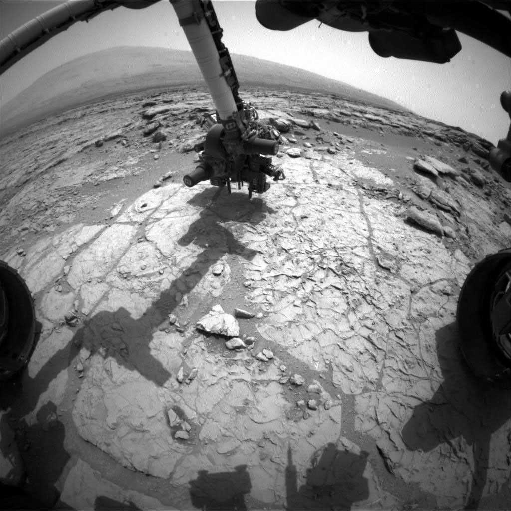 The percussion drill in the turret of tools at the end of the robotic arm of NASA's Mars rover Curiosity has been positioned in contact with the rock surface in this image from the rover's front Hazard-Avoidance Camera (Hazcam).
