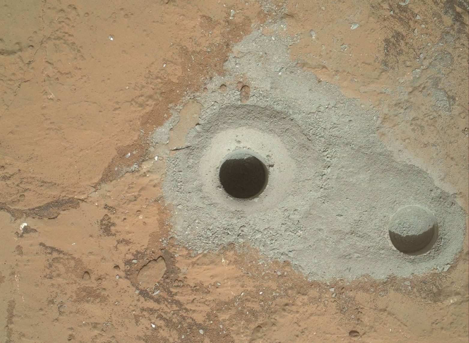 At the center of this image from NASA's Curiosity rover is the hole in a rock called 'John Klein' where the rover conducted its first sample drilling on Mars.