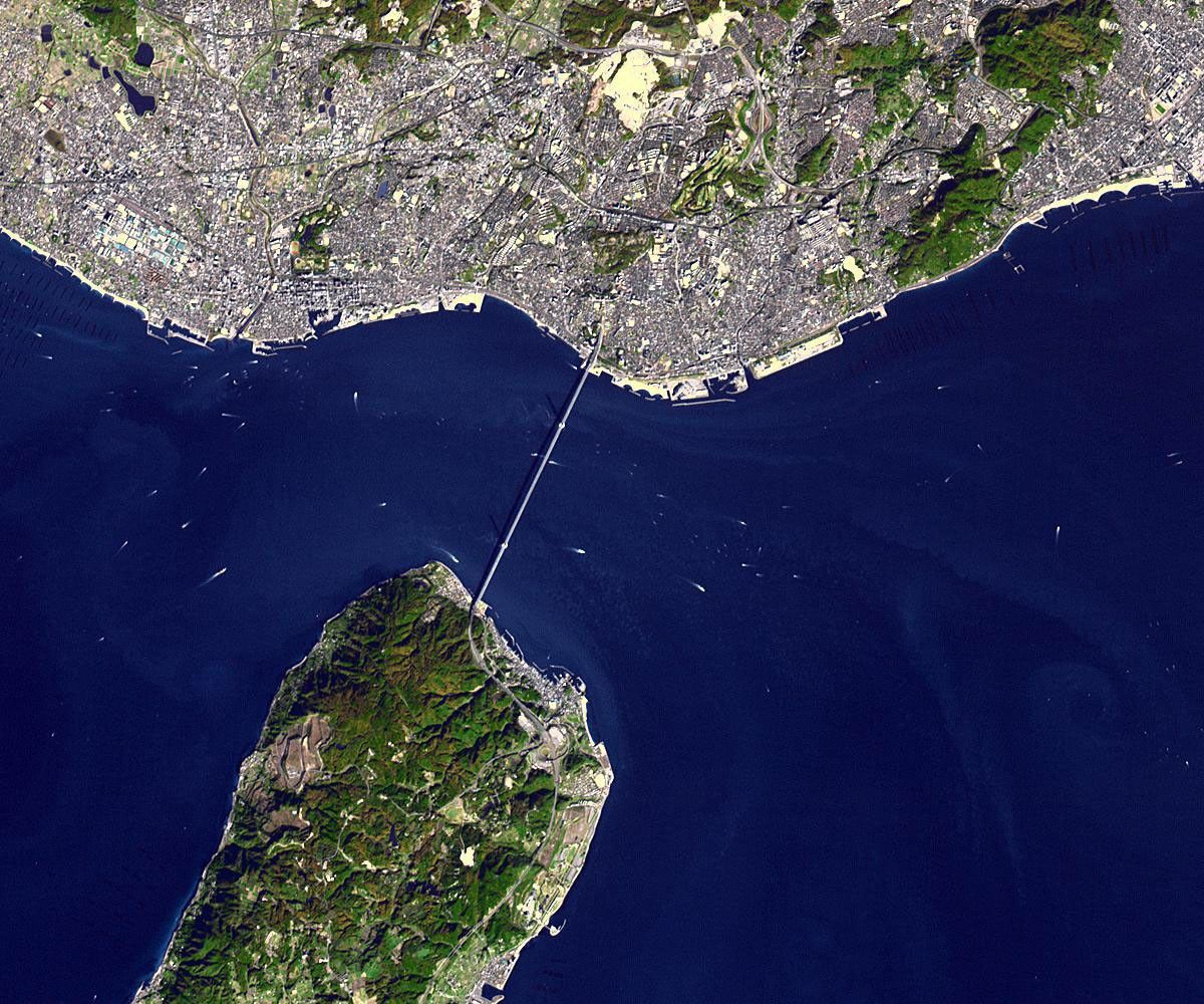 NASA's Terra spacecraft shows the Akashi Kaikyo Bridge (or Pearl Bridge), the longest central span of any suspension bridge in the world, at 1991 meters, connecting the city of Kobe, Japan with Iwaja on Awaji Island by crossing the busy Akashi Strait.