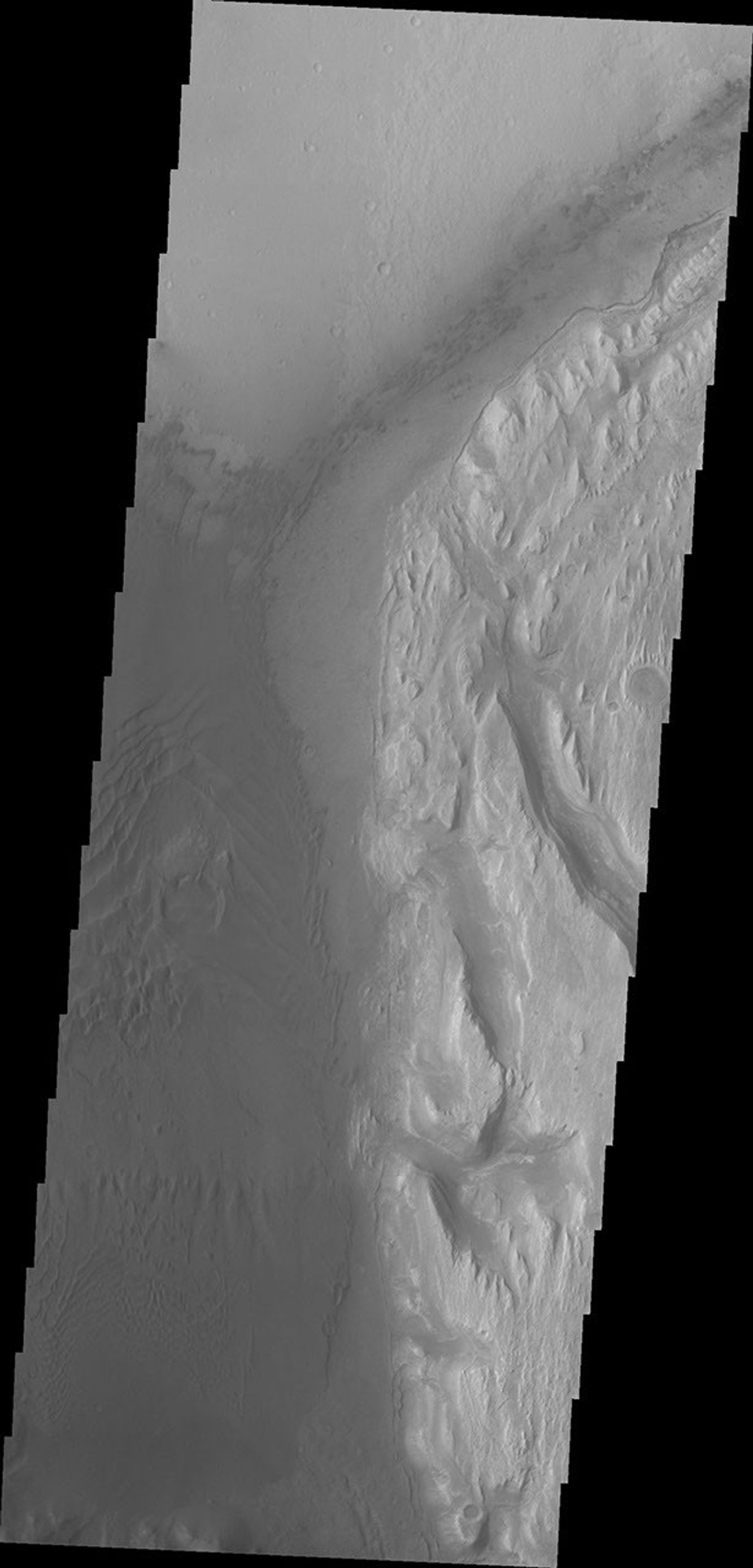 This image from NASA's Mars Odyssey spacecraft shows the western margin of Mt. Sharp. The large channel from past images enters the frame in the center and then veers to the northwest. A large region of sand and sand dunes covers the crater floor.