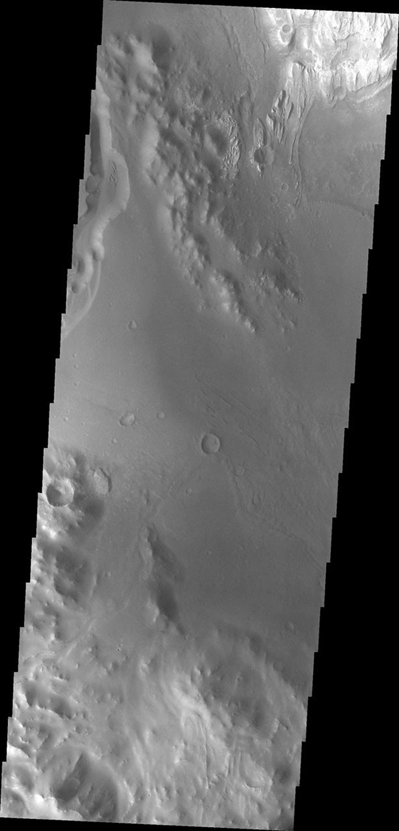 NASA's Mars Odyssey spacecraft shows a large channel on Mars. Just below the brighter material of Mt. Sharp is the start of the arced edge of material.