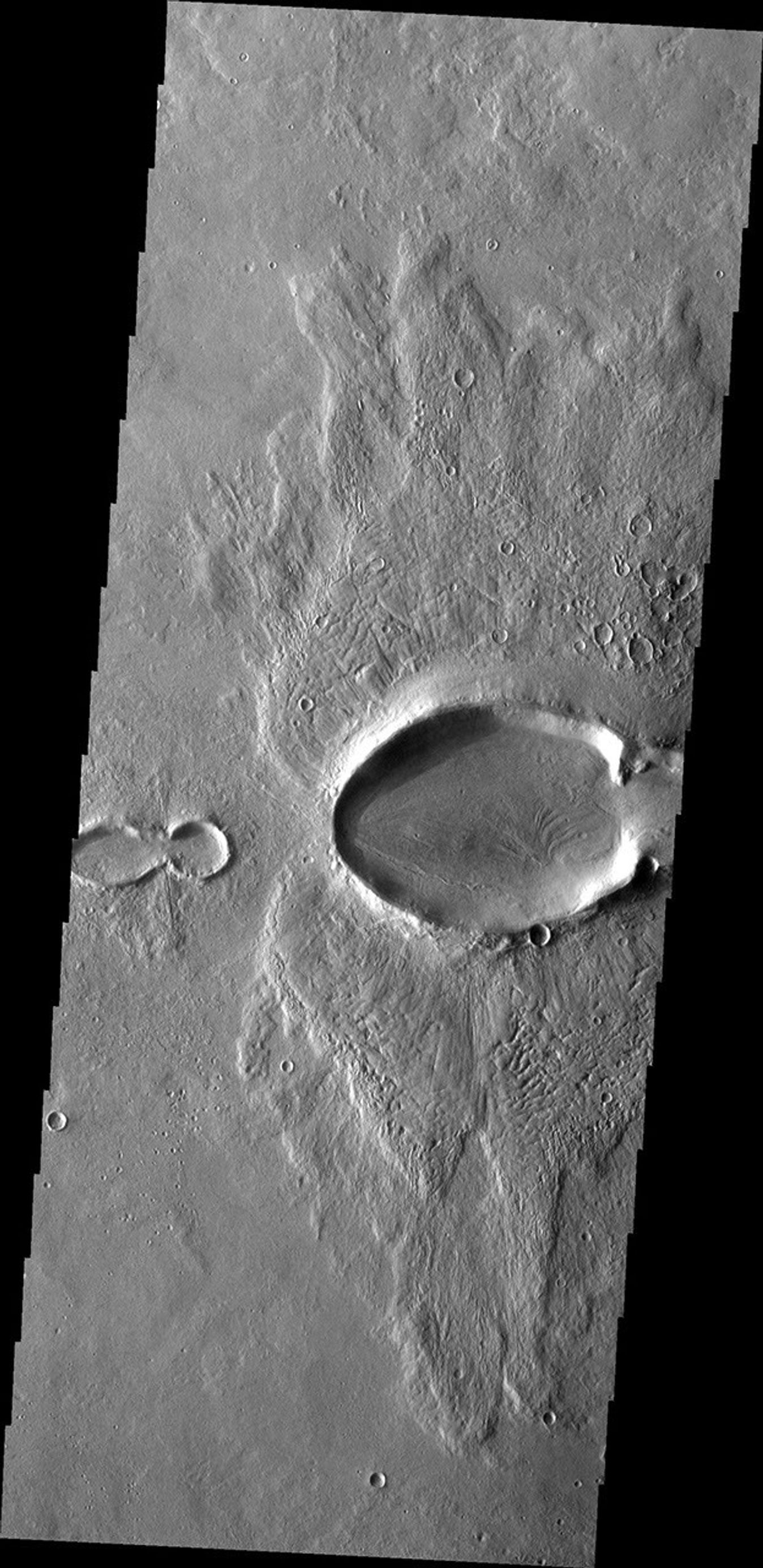 This image from NASA's Mars Odyssey spacecraft shows multiple craters on Mars resembling a baby bug following the larger mama bug.
