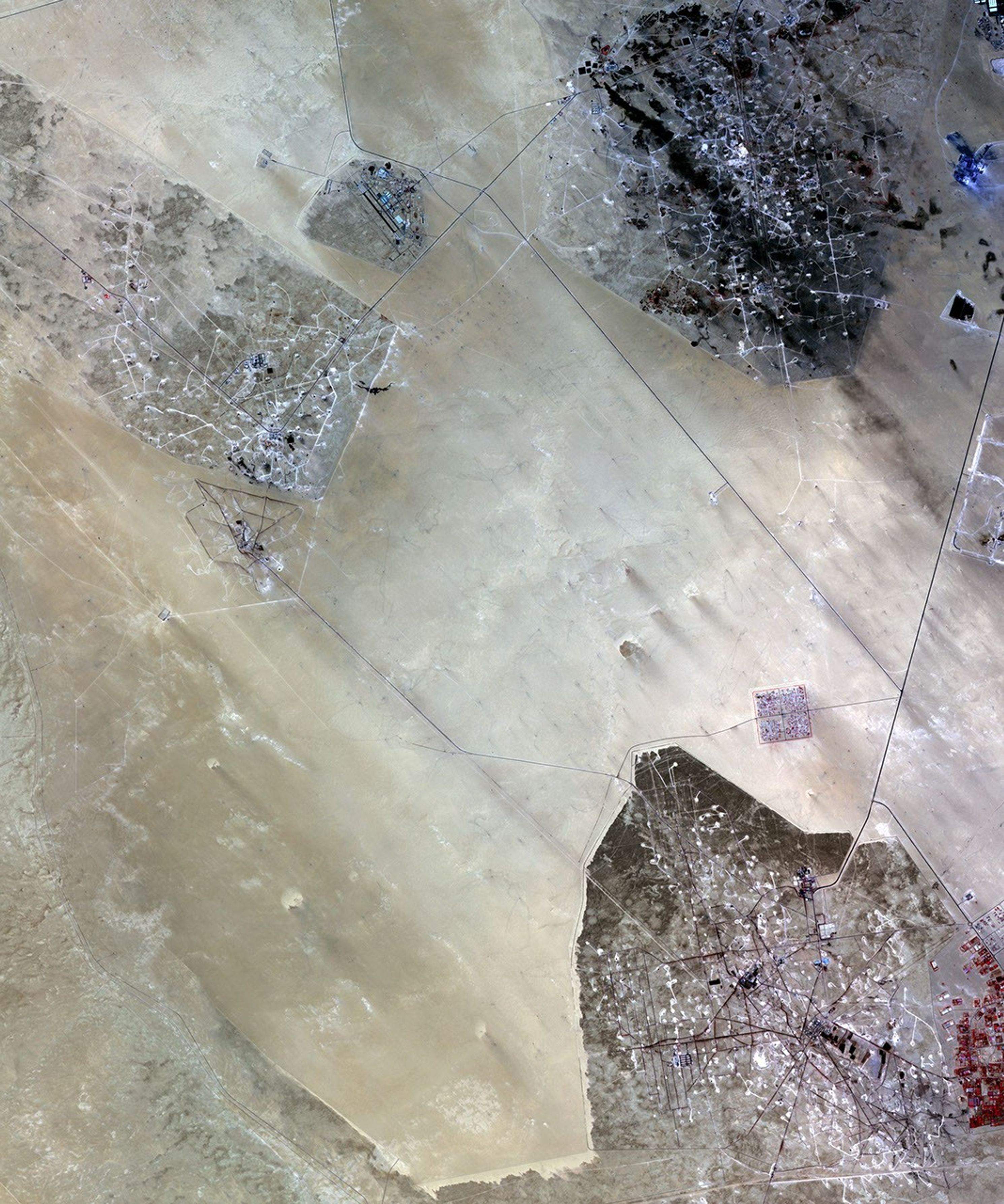 In the desert of southern Kuwait, three oil fields spread out across the empty landscape as seen by NASA's Terra spacecraft.