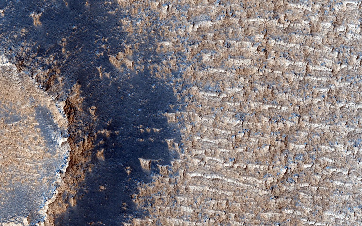 This image from NASA's Mars Reconnaissance Orbiter shows curious bright deposits in Syria Planum, a high elevation region near the summit of the Tharsis rise.