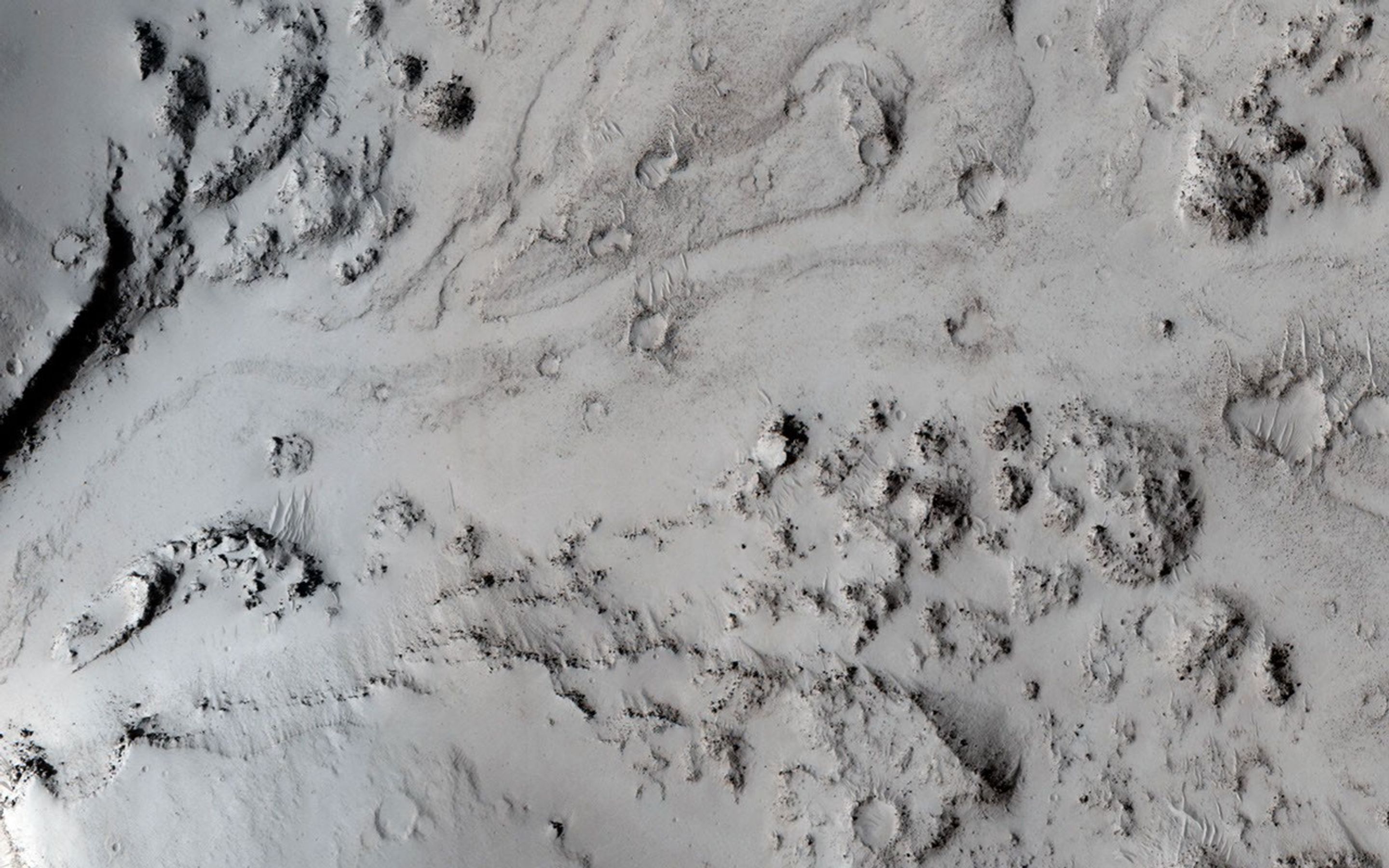 In this image from NASA's Mars Reconnaissance Orbiter, we can see a small notch in a crater rim with a well-formed channel. Lava appears to have flowed through this notch and filled in this crater.