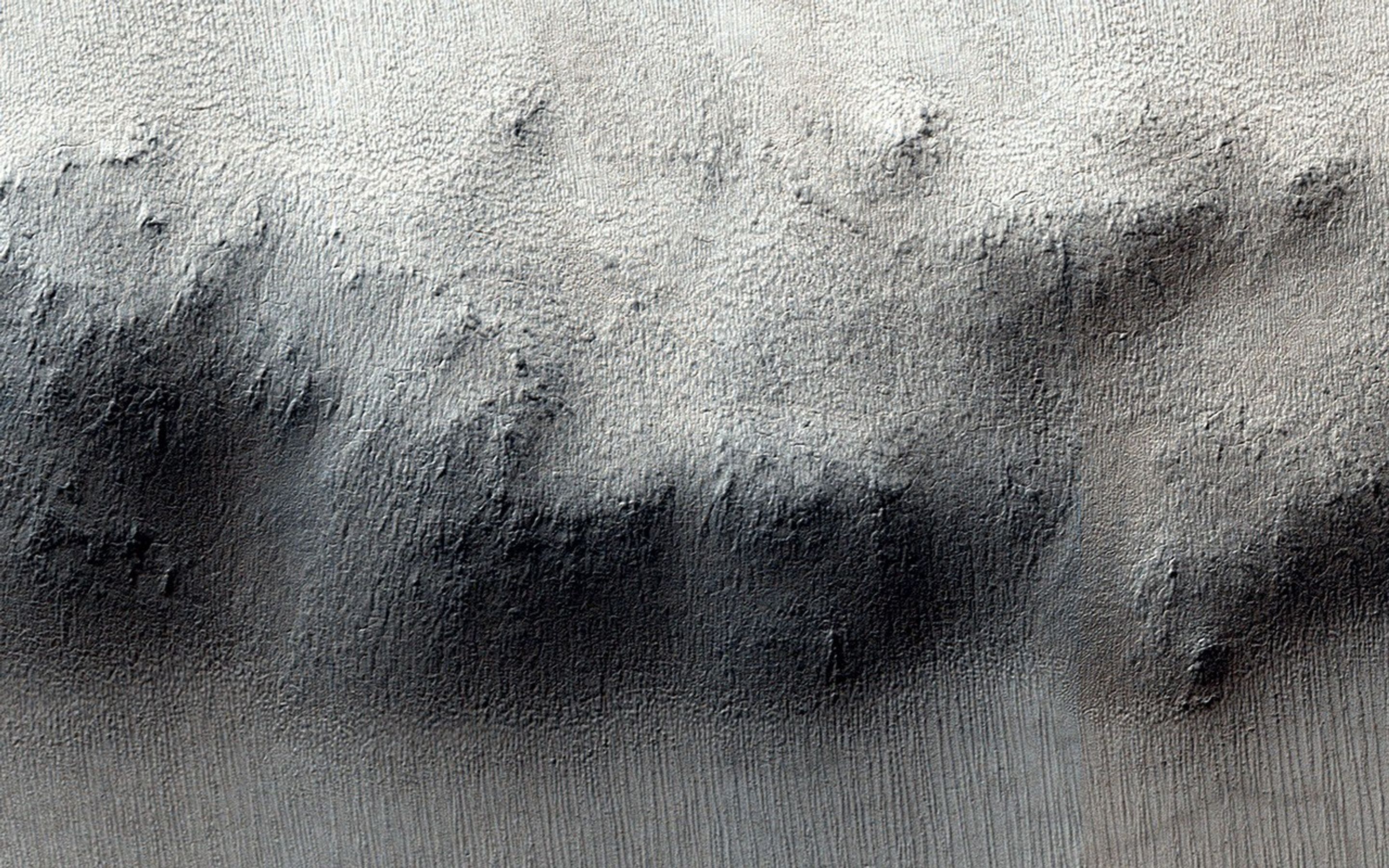 These craters on Tharsis are first visible as new dark spots observed by NASA's Mars Reconnaissance Orbiter's Context Camera (CTX), which can view much larger areas, and then imaged by HiRISE for a close-up look.