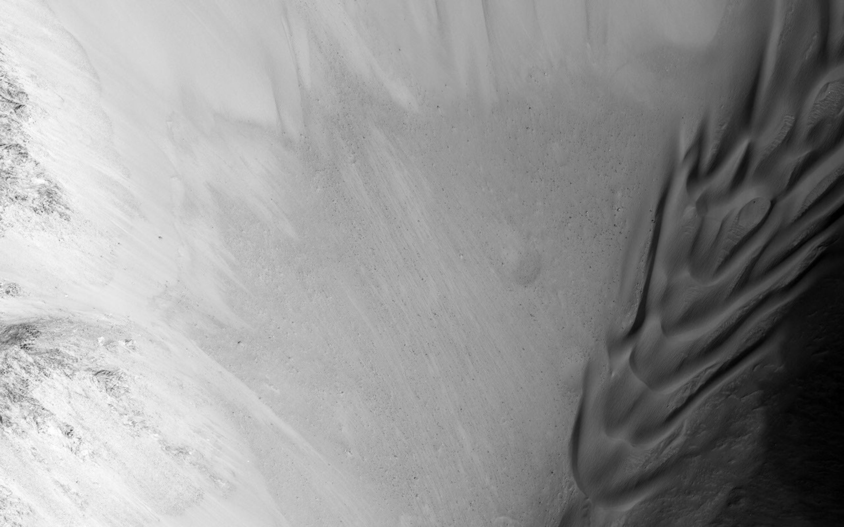 This image from NASA's Mars Reconnaissance Orbiter shows a transect of Coprates Chasma wall stratigraphy, which includes (moving down sequence): the southern plateau, wall spurs, fans of eroded material, gullies, sand dunes, and canyon floor.