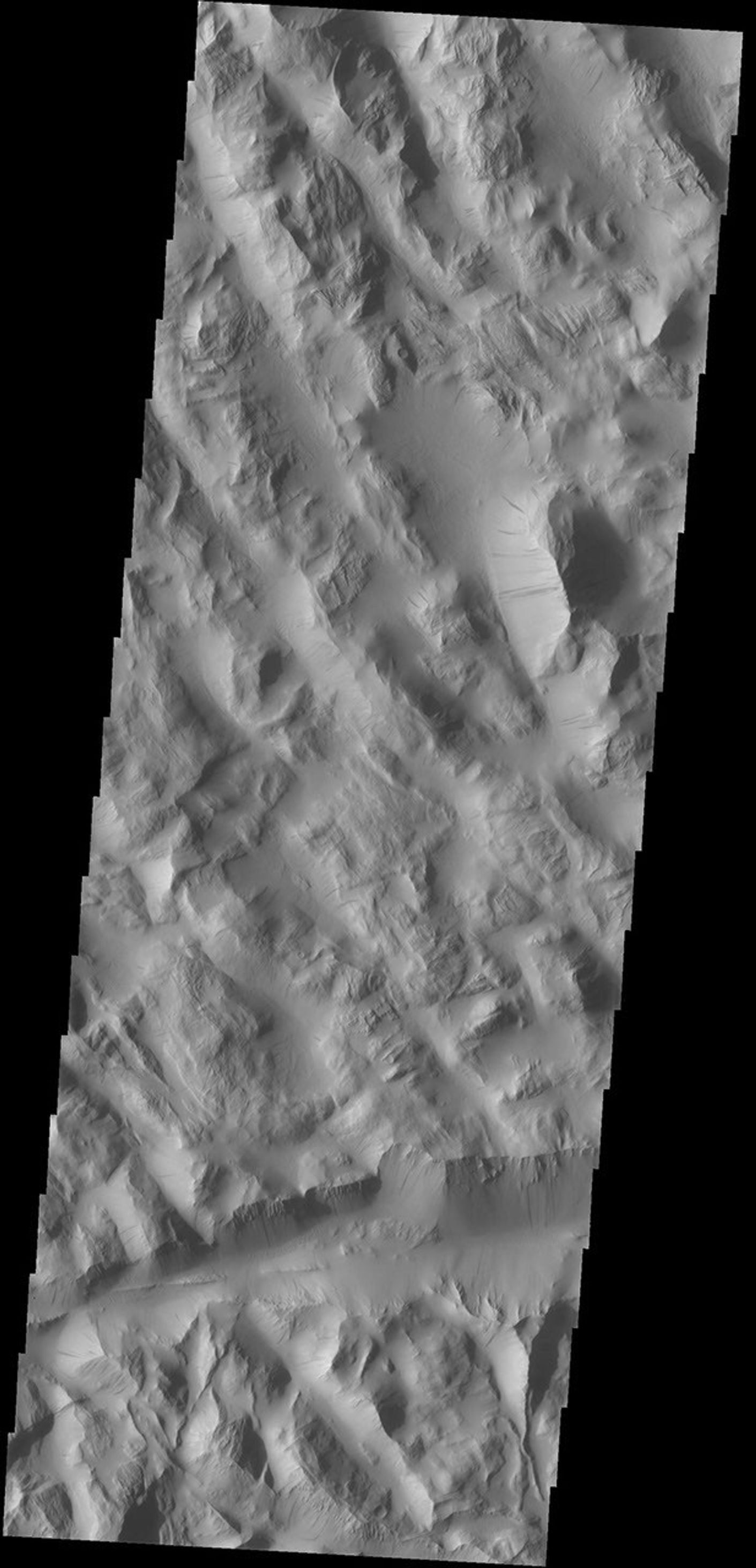 Dark slope streaks mark the hill sides in Lycus Sulci as seen by NASA's 2001 Mars Odyssey spacecraft.