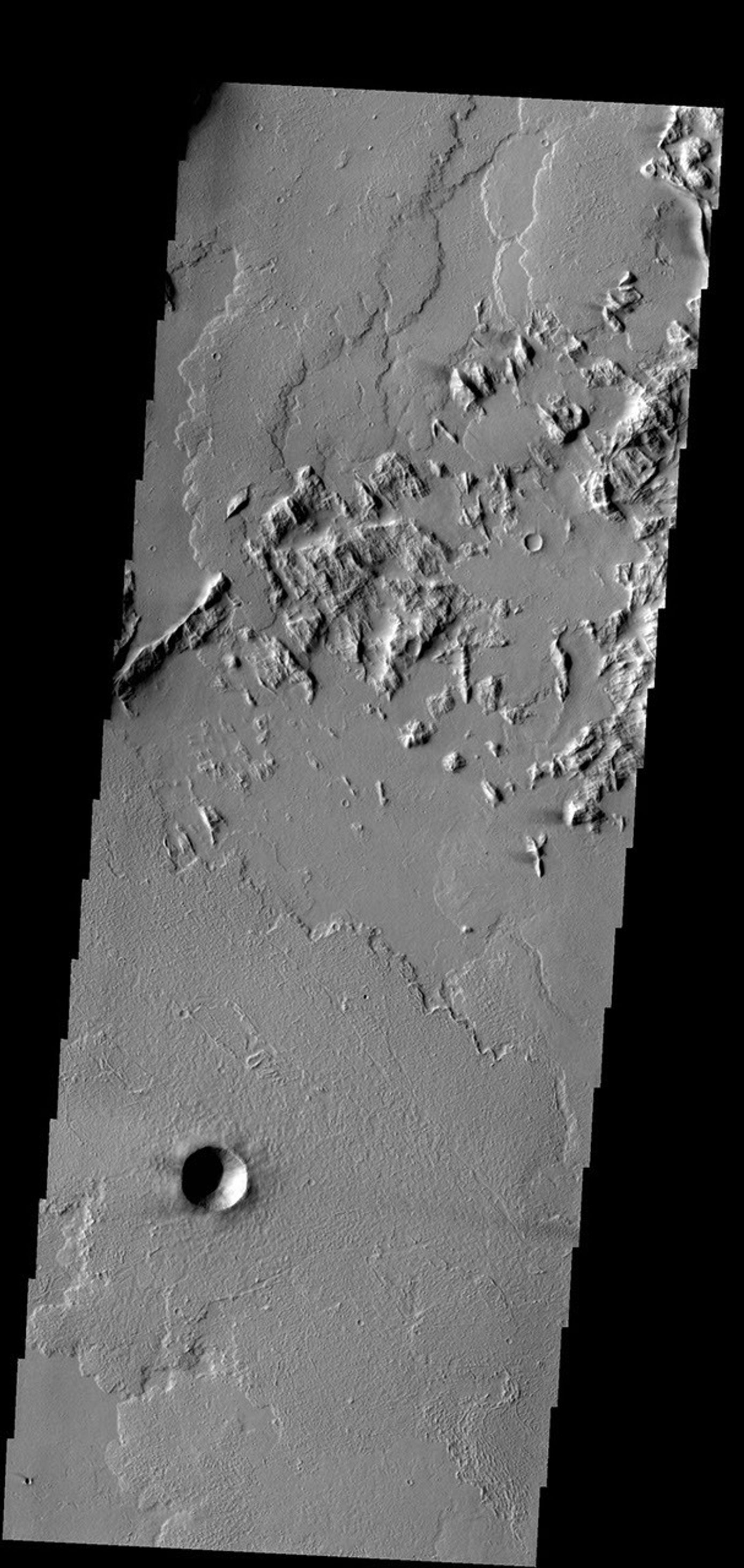 This image captured by NASA's 2001 Mars Odyssey spacecraft is located southwest of Olympus Mons, shows the end of a lava flow that has flowed between the hills at the upper left portion of the image.