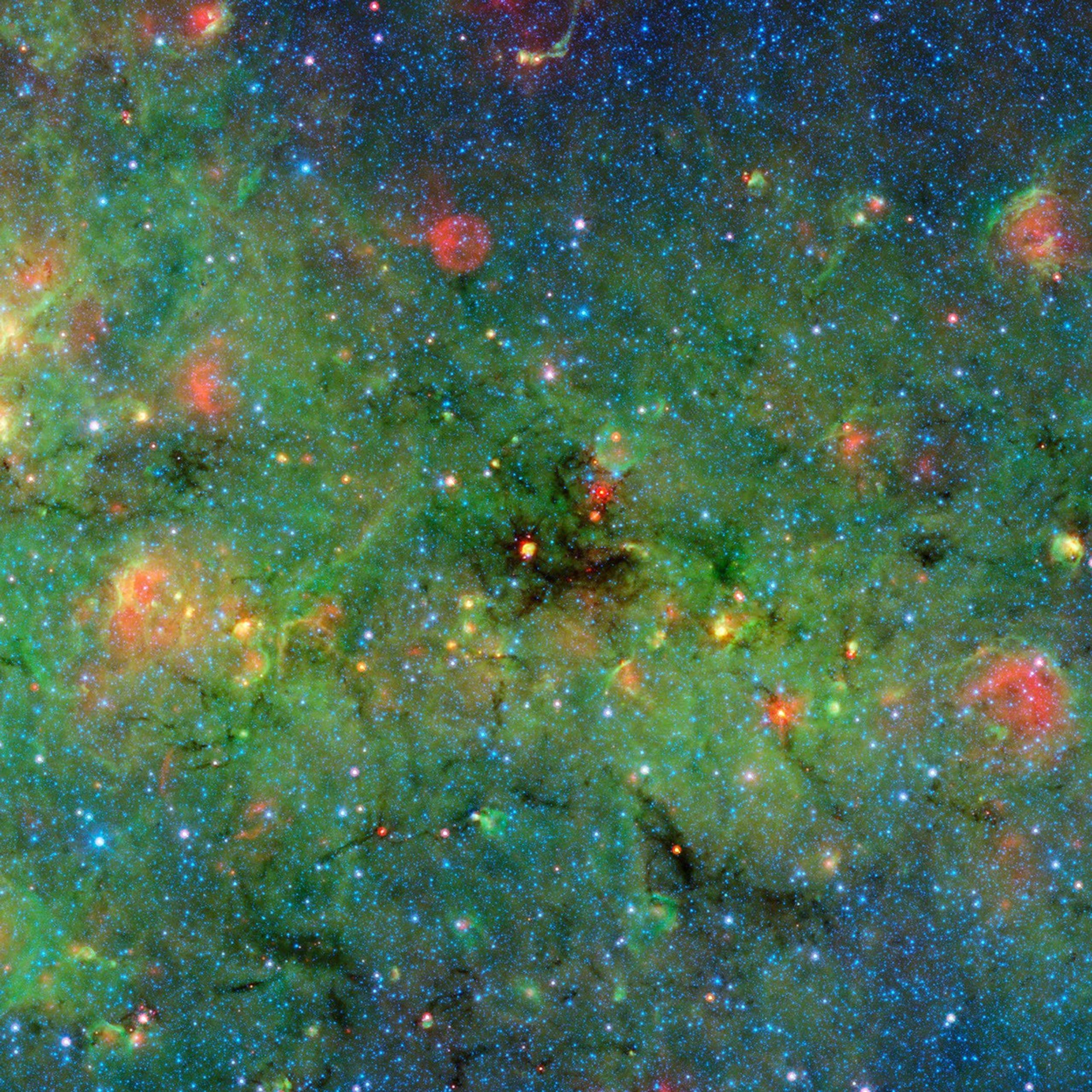 Astronomers have found cosmic clumps so dark, dense and dusty that they throw the deepest shadows ever recorded. A large cloud looms in the center of this image of the galactic plane from NASA's Spitzer Space Telescope.