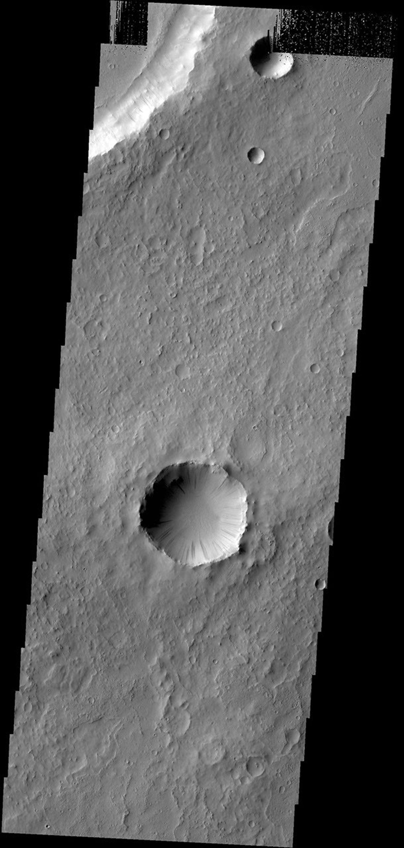 Dark slope streaks are found everywhere on the inner rim of this unnamed crater in Arabia Terra in this image captured by NASA's 2001 Mars Odyssey spacecraft.