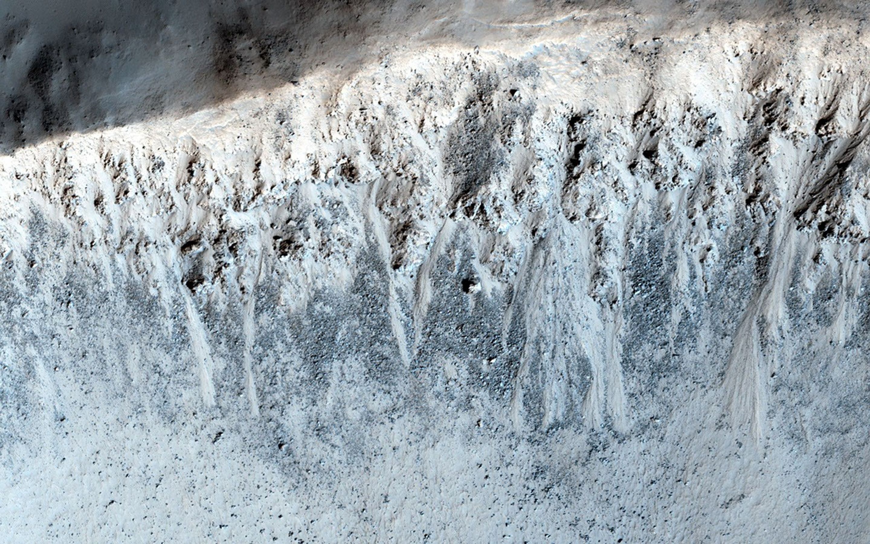 This image from NASA's Mars Reconnaissance Orbiter shows a 3-kilometer-wide impact crater with gullies all along the steep inner slopes.