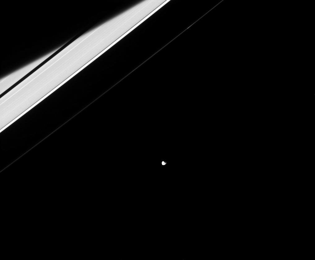 In reality, Janus and the rings both orbit Saturn and are only weakly connected to each other through their mutual gravitational tugs as seen by NASA's Cassini spacecraft.