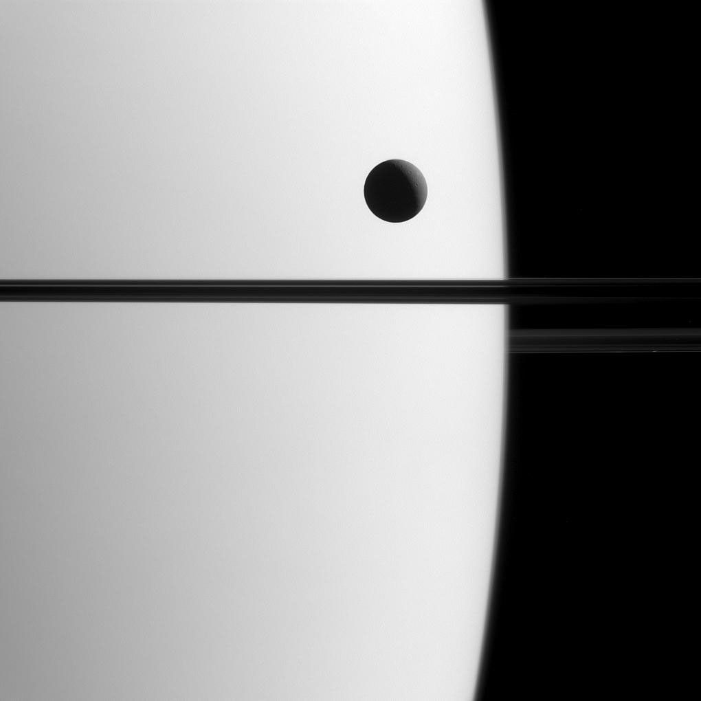 Saturn's moon Dione crosses the face of the giant planet in this view from NASA's Cassini spacecraft. Astronomers call this phenomenon a transit.
