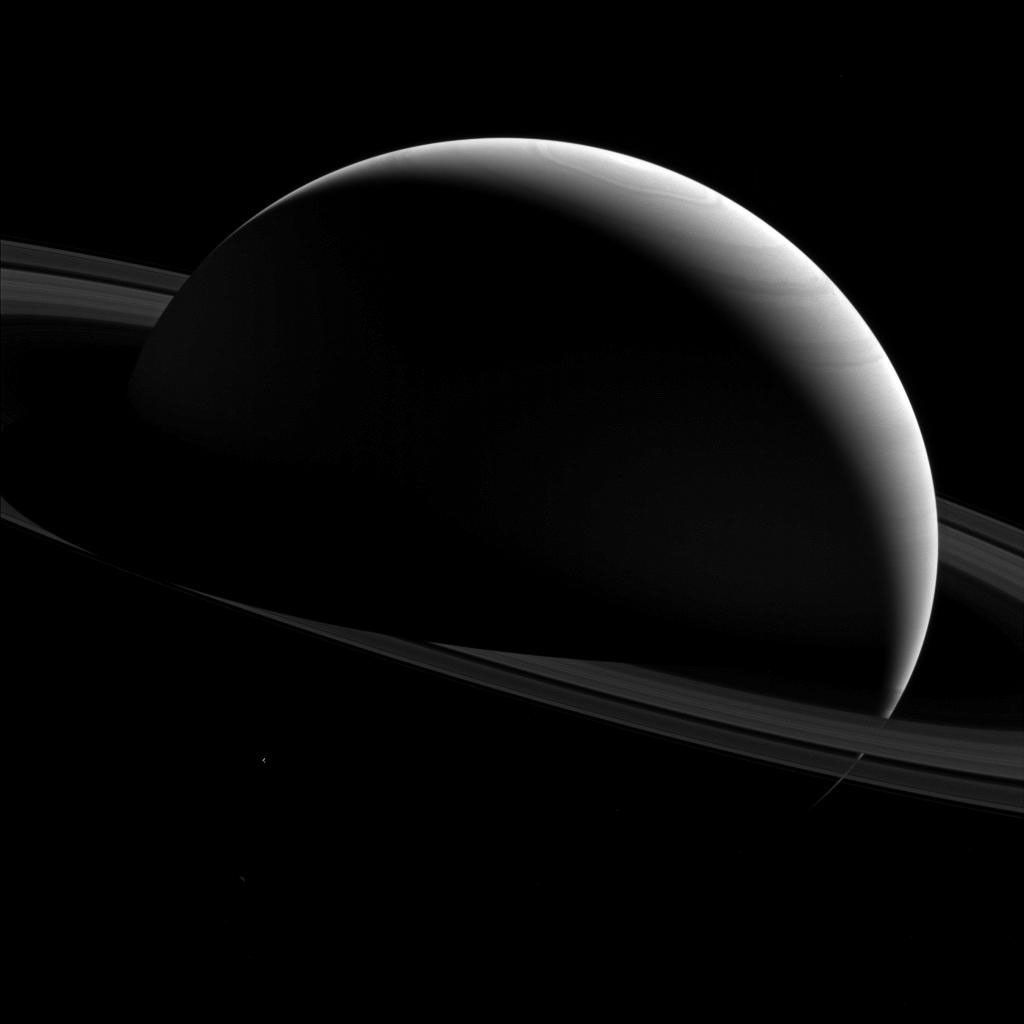 The night sides of Saturn and Tethys are dark places indeed. This image from NASA's Cassini spacecraft shows shadows are darker areas than sunlit areas, and in space, with no air to scatter the light, shadows can appear almost totally black.