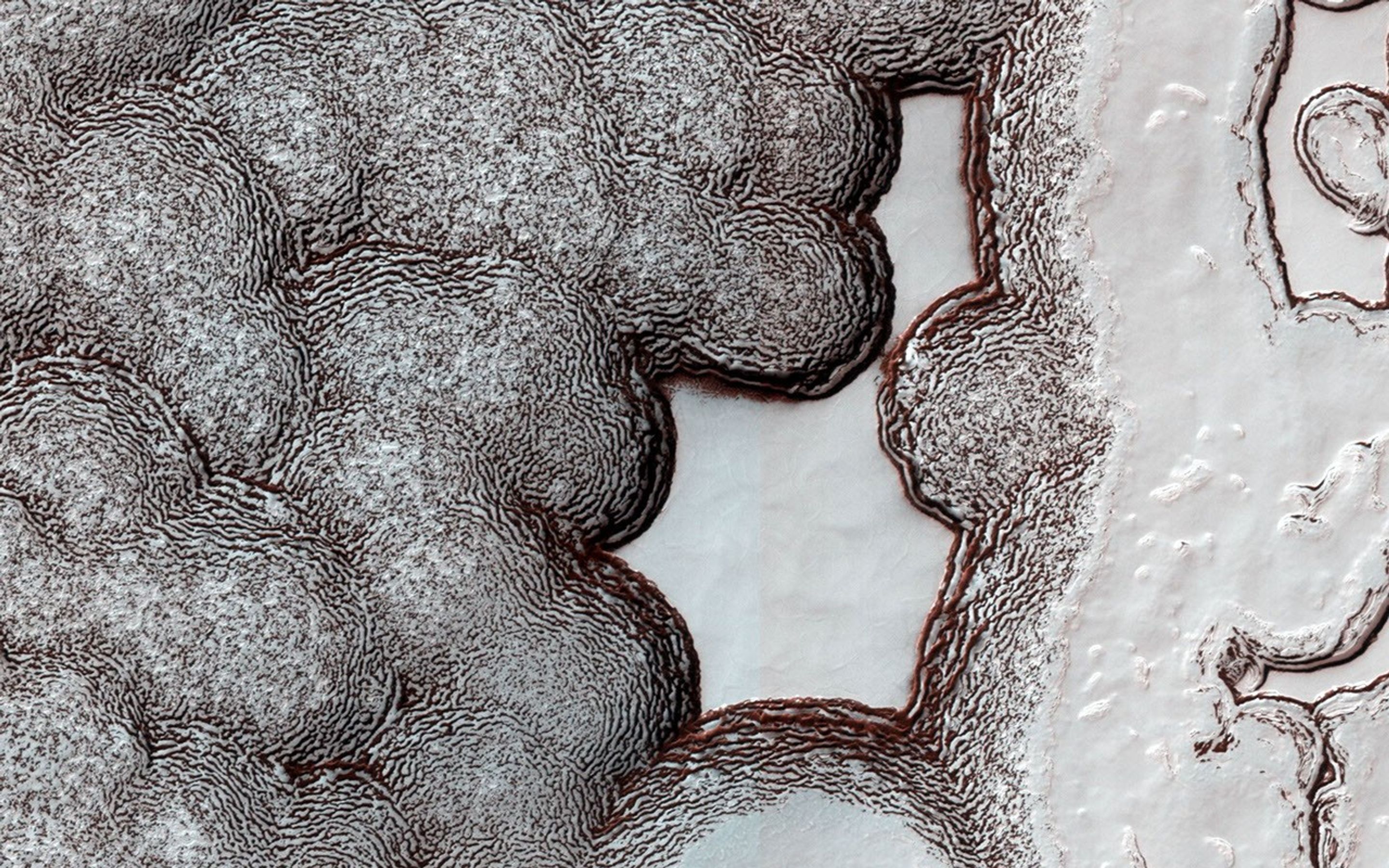 Although Mars' soloar cap survives each warm summer season, it is constantly changing its shape due to sublimation of carbon dioxide from steep slopes and deposition onto flat areas as seen in this image from NASA's Mars Reconnaissance Orbiter.