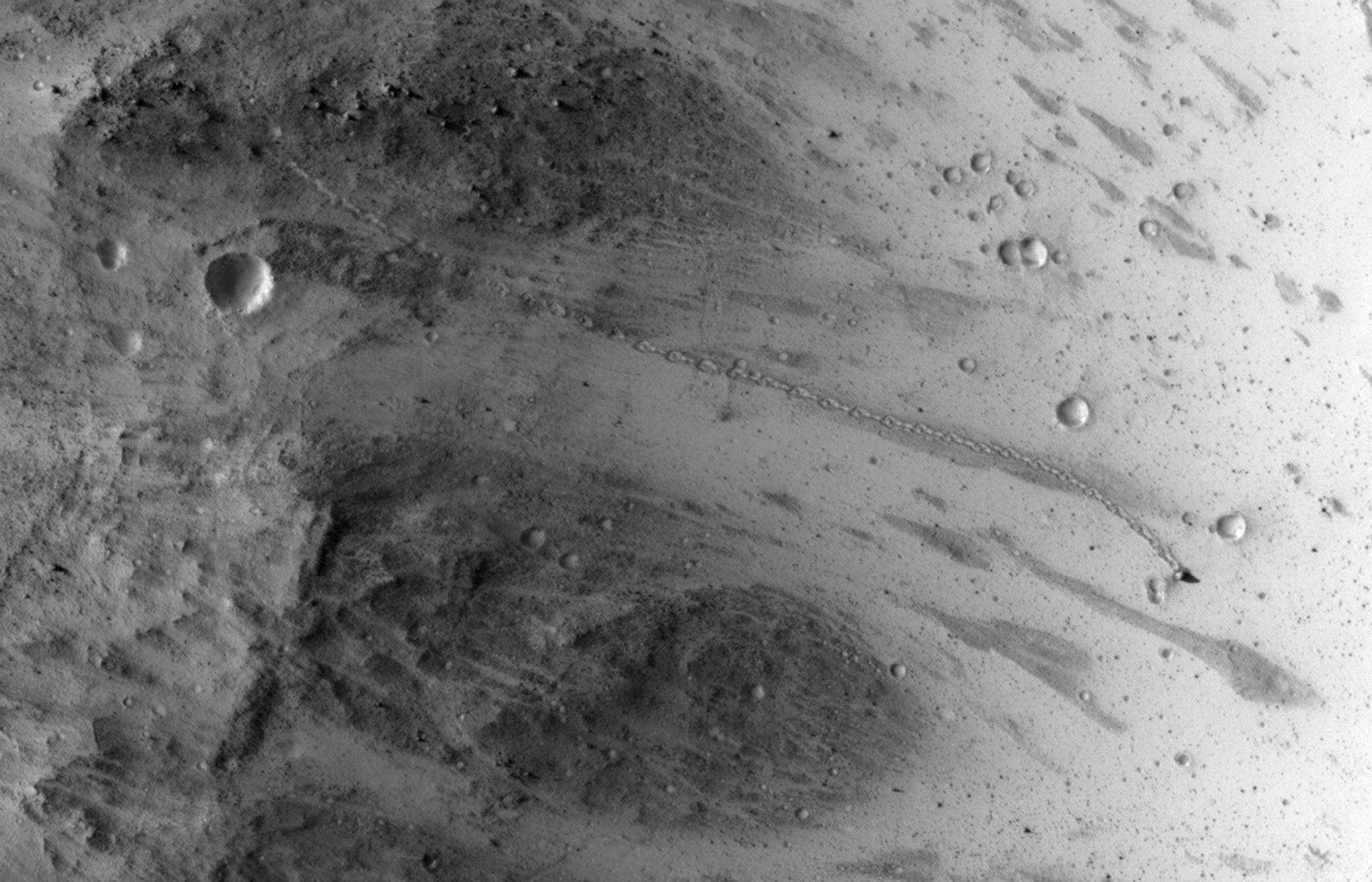 The track left by an oblong boulder as it tumbled down a slope on Mars runs from upper left to right center of this image taken by NASA's Mars Reconnaissance Orbiter.
