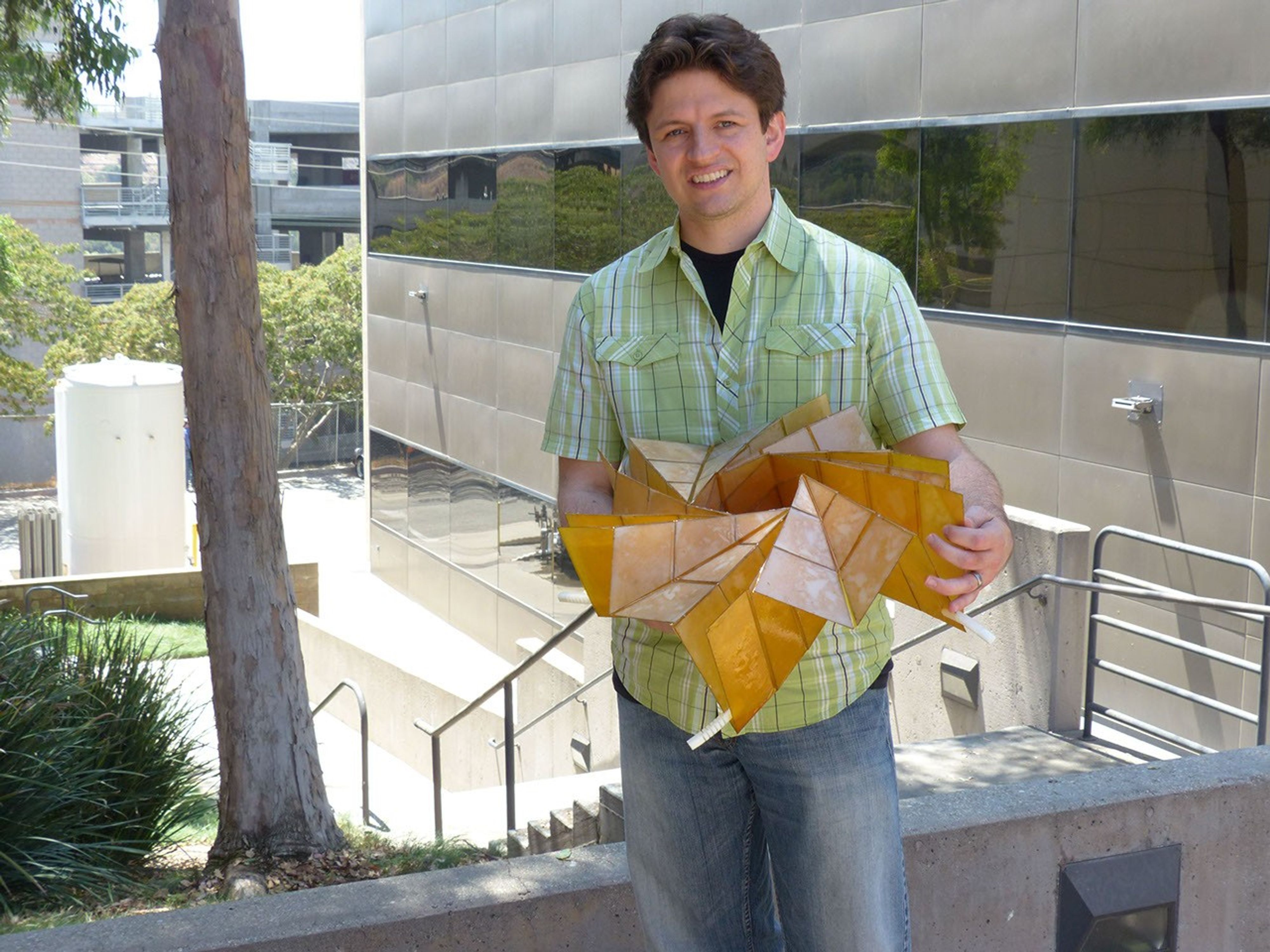 A researcher at NASA's Jet Propulsion Laboratory in Pasadena, holds a prototype of a solar panel array that folds up in the style of origami.