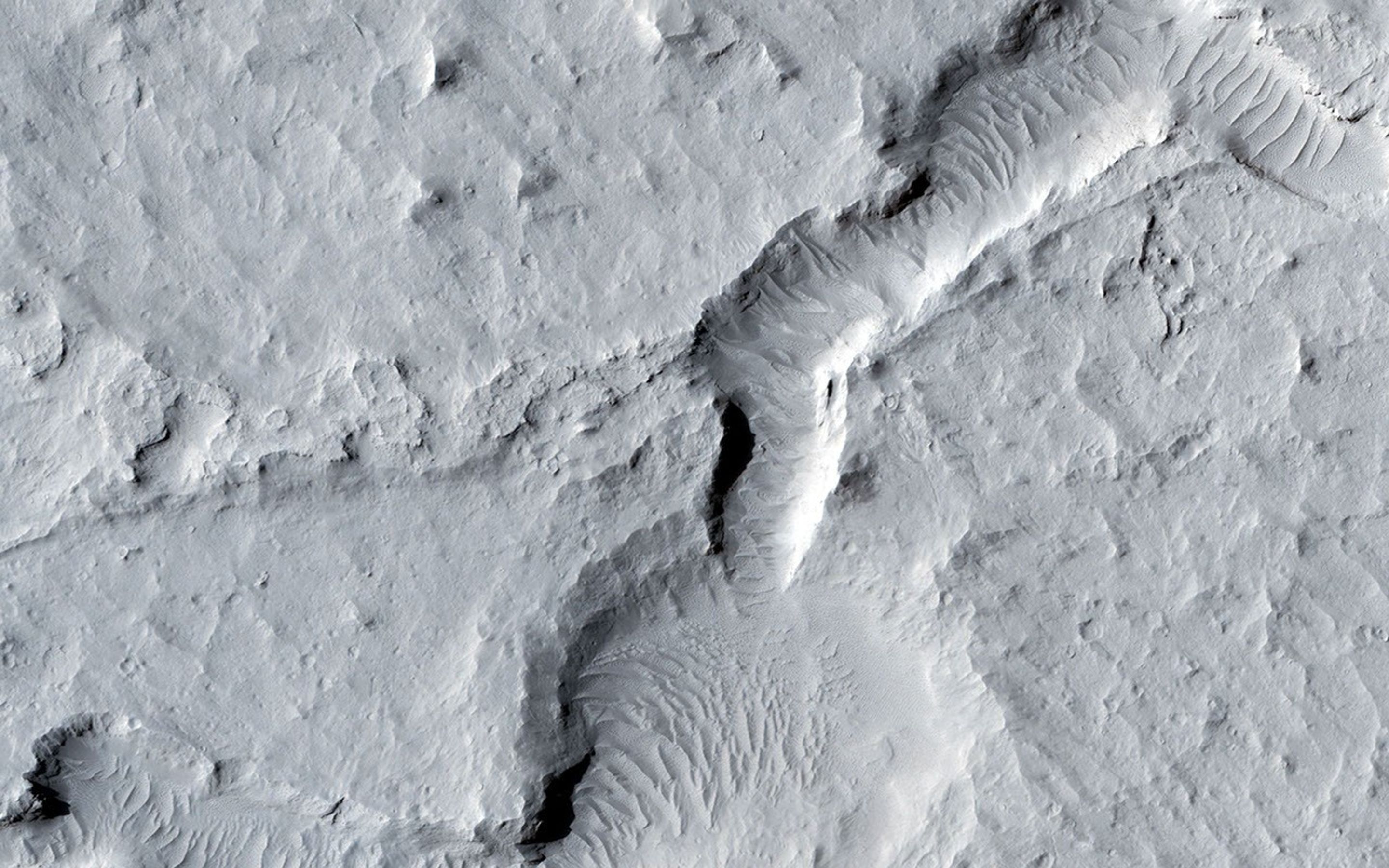 In the northern section of this from image NASA's Mars Reconnaissance Orbiter, we see flat terrain that is probably an ancient lava field. These dust avalanches are common in dust-covered regions on Mars.