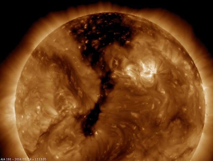 NASA's Solar Dynamics Observatory shows a long coronal hole has rotated so that was temporarily facing right towards Earth (Mar. 23-25, 2016). Coronal holes appear dark when viewed in some wavelengths of extreme ultraviolet light.