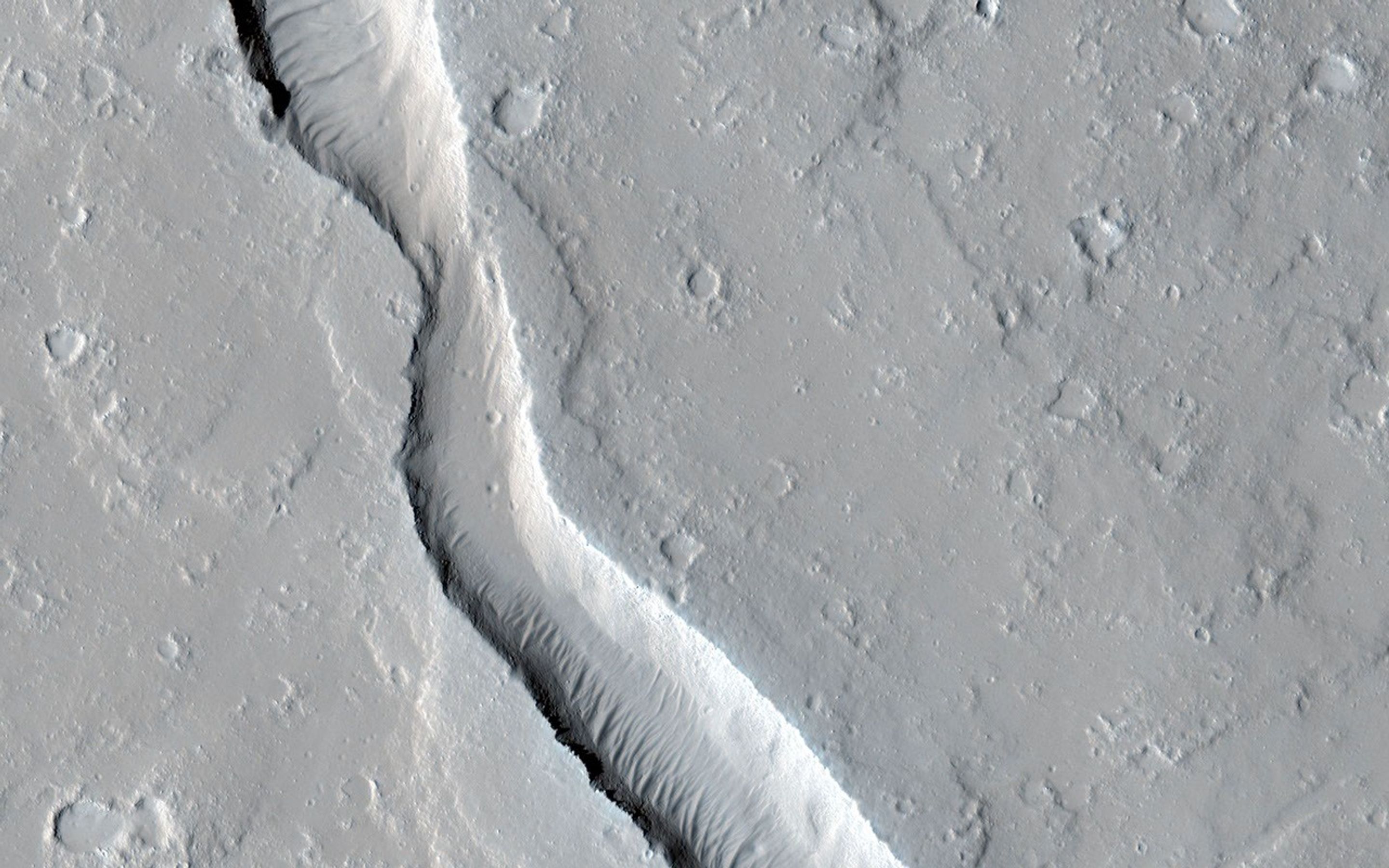 This image from NASA's Mars Reconnaissance Orbiter shows a lava channel, which lies just to the east of the largest volcano in the solar system: Olympus Mons.