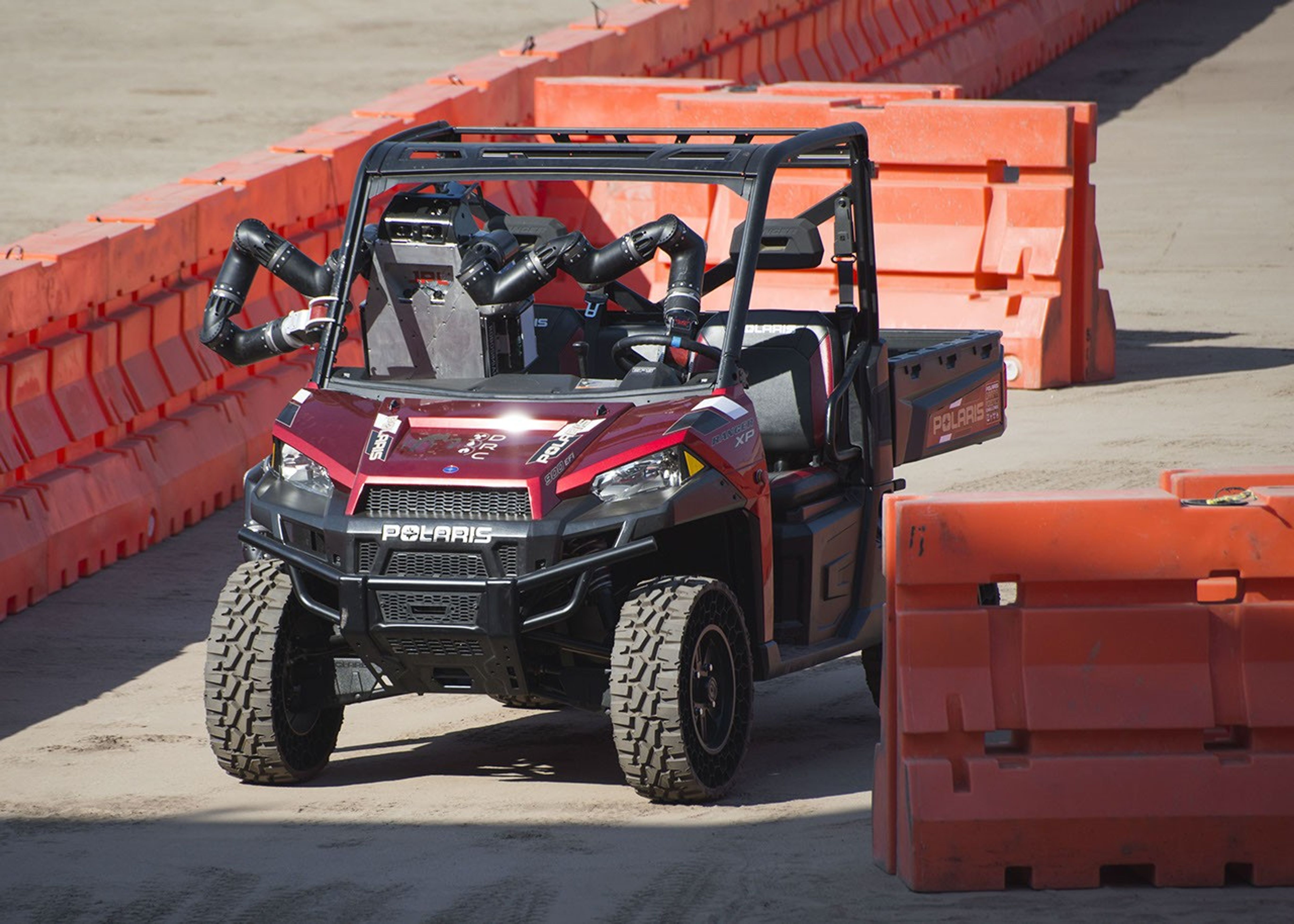 JPL's RoboSimian drives a four-wheeled vehicle through a slalom course at the DARPA Robotics Challenge Finals.