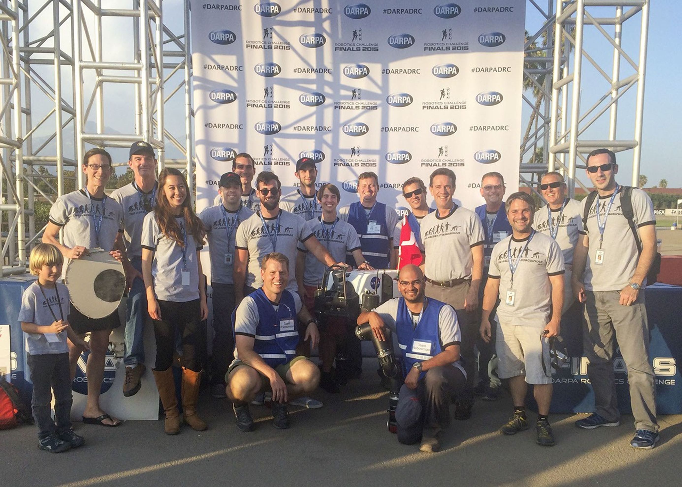 Many members of Team RoboSimian and a few guests gather with competition hardware at a 'Meet the Robots' event during the DARPA Robotics Challenge Finals in Pomona, California, on June 6, 2015.