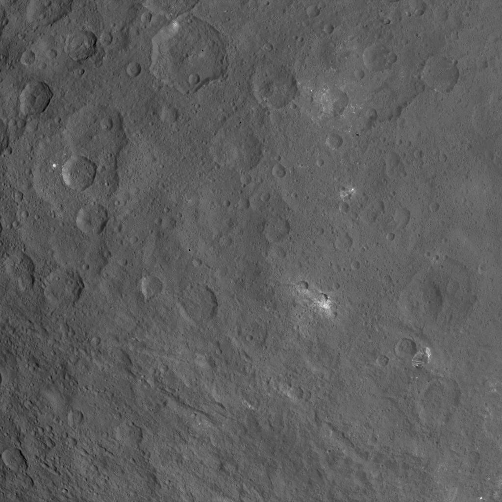 This image of Ceres, taken by NASA's Dawn spacecraft, features a large, steep-sided mountain and several intriguing bright spots. The mountain's height is estimated to be about 4 miles (6 kilometers). It is the highest point seen on Ceres so far.