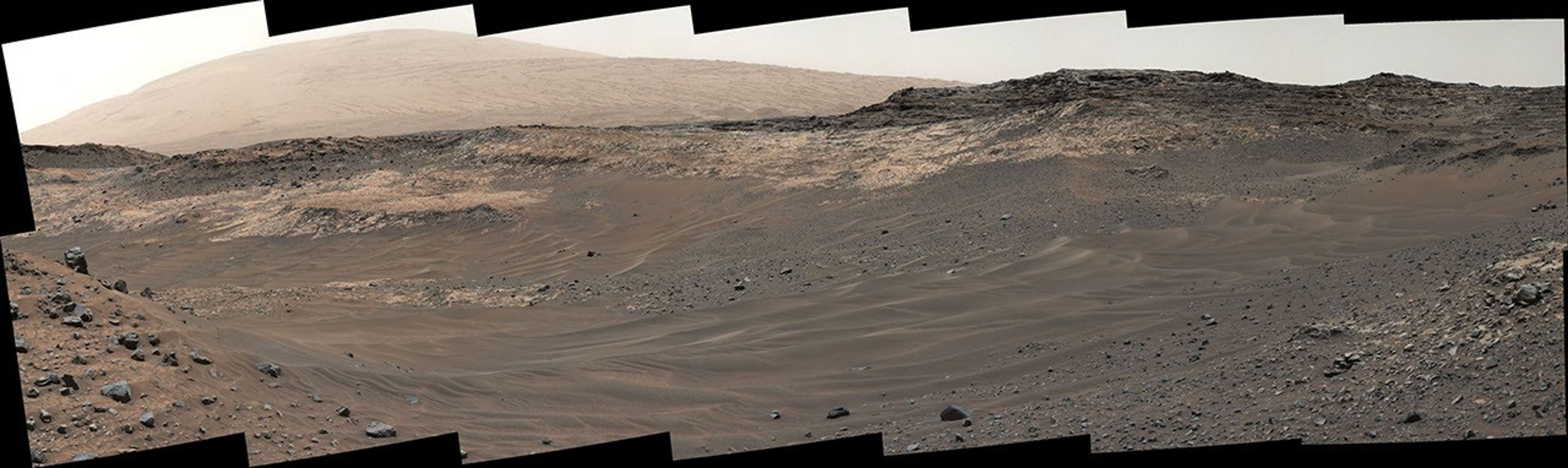 This view southeastward from NASA's Curiosity's Mastcam shows terrain judged difficult for traversing between the rover and an outcrop in the middle distance where a pale rock unit meets a darker rock unit above it.