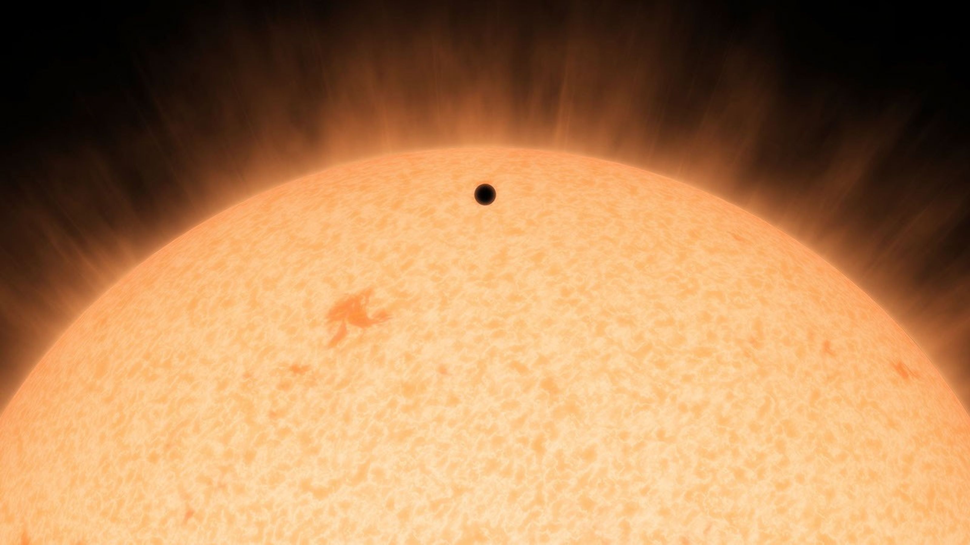 This artist's conception shows the silhouette of a rocky planet, dubbed HD 219134b, as it passes in front of its star. At 21 light-years away, the planet is the closest outside of our solar system that can be seen crossing, or transiting, its star.