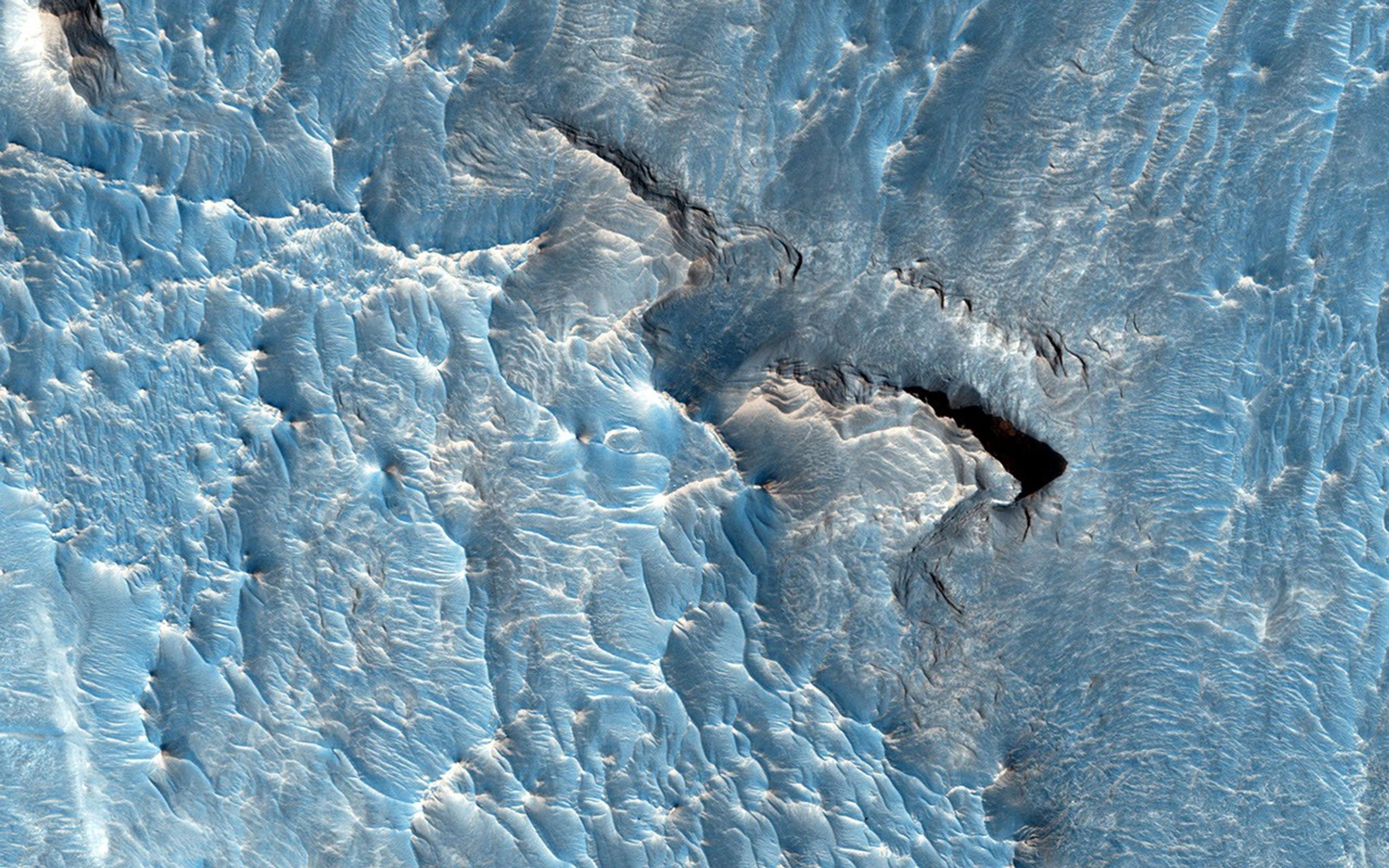 The objective of this observation from NASA's Mars Reconnaissance Orbiter is to examine a light-toned deposit in a region of what is called 'chaotic terrain.' Some shapes suggest erosion by a fluid moving north and south.