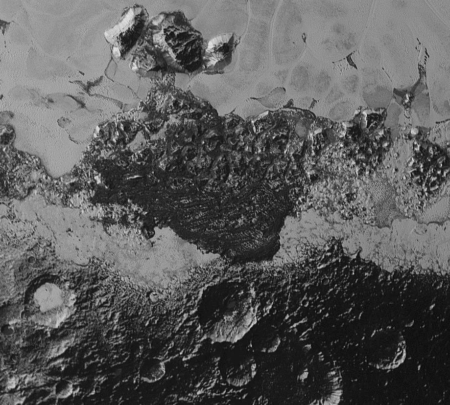 This image from NASA's New Horizons includes dark, ancient heavily cratered terrain, bright, smooth geologically young terrain, assembled masses of mountains, and an enigmatic field of dark, aligned ridges that resemble dunes.
