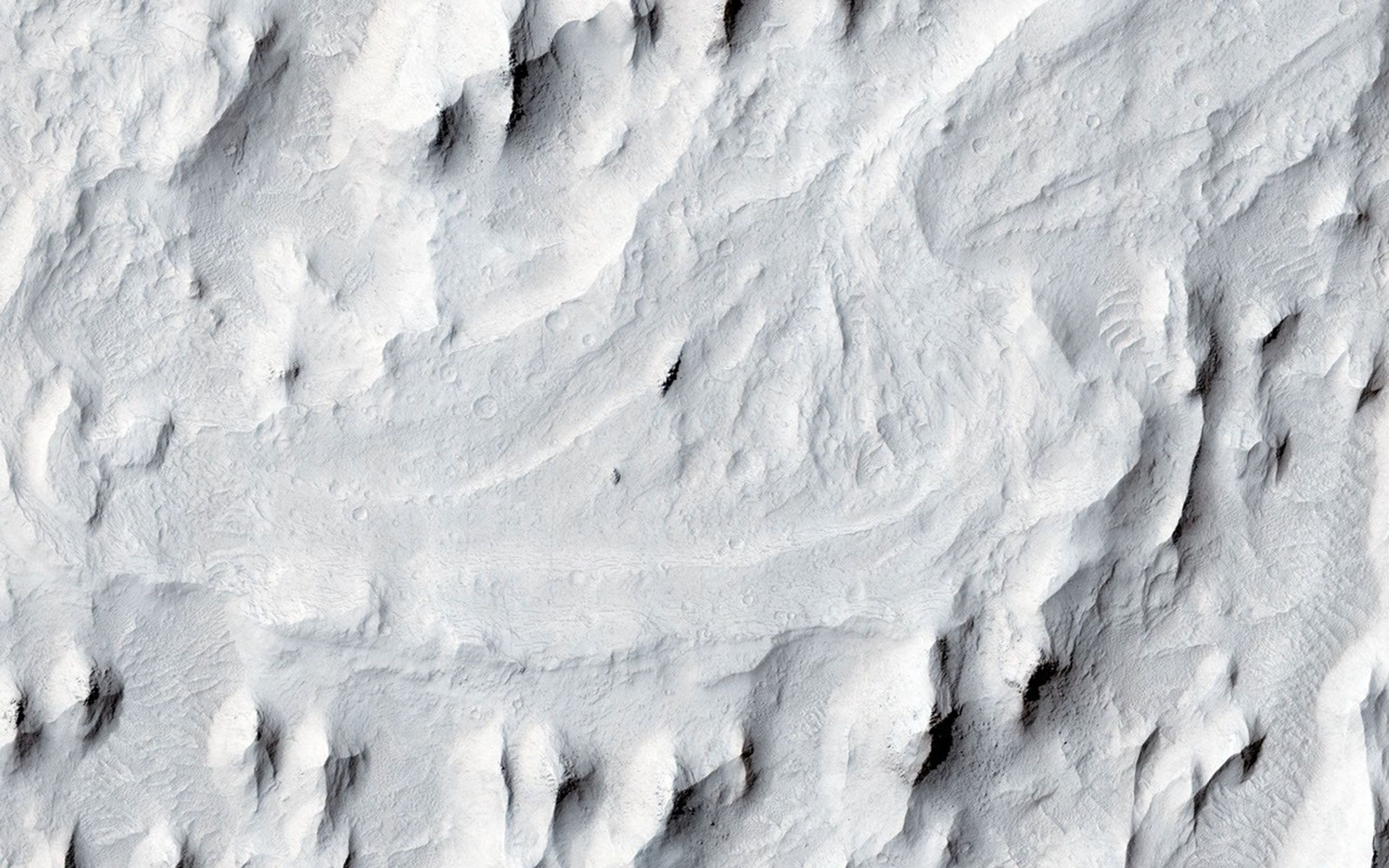 In this image from NASA's Mars Reconnaissance Orbiter spacecraft, an ancient sinuous meandering river system is surrounded by features called 'yardangs.' The yardangs are the ridge-like landforms that align approximately north-south.