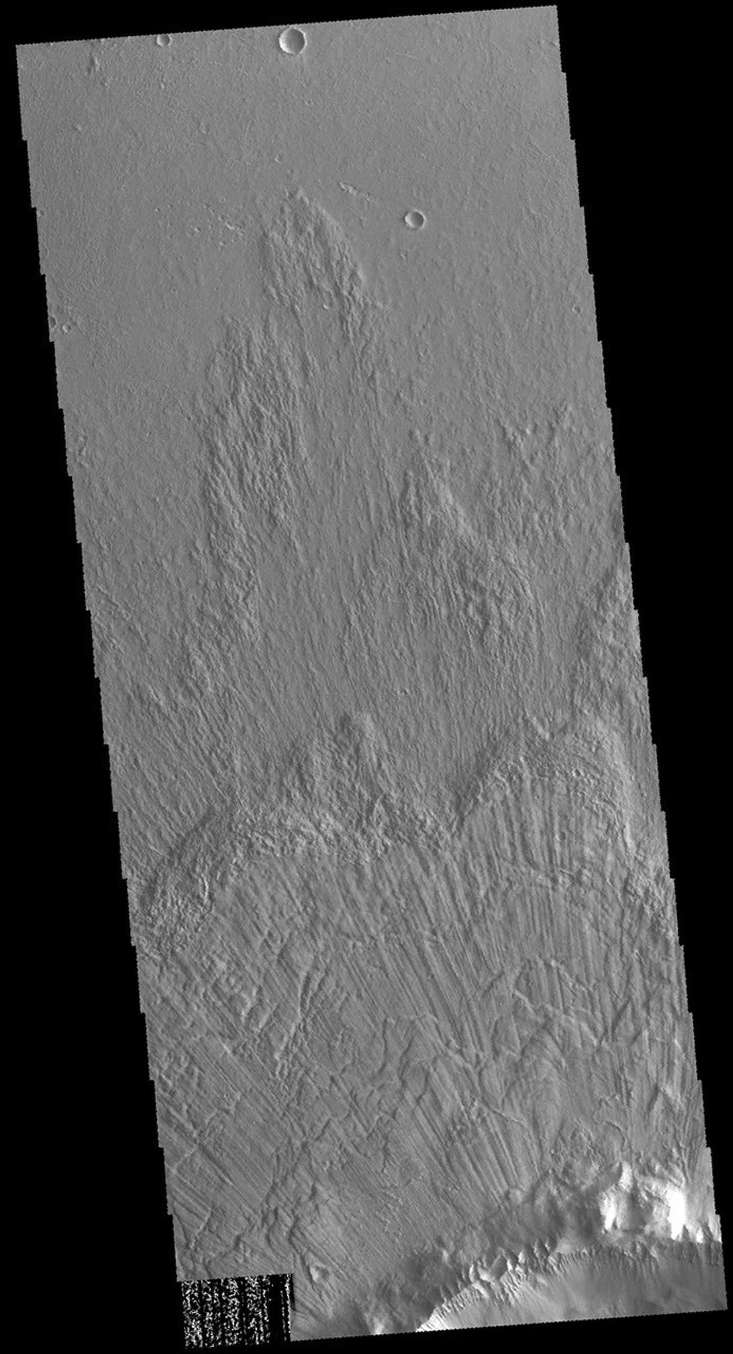 This image captured by NASA's 2001 Mars Odyssey spacecraft show part of the ejecta of Bacolor Crater. The ejecta is layered and grooved, all radial to the crater itself. Bacolor Crater is located in Utopia Planitia.