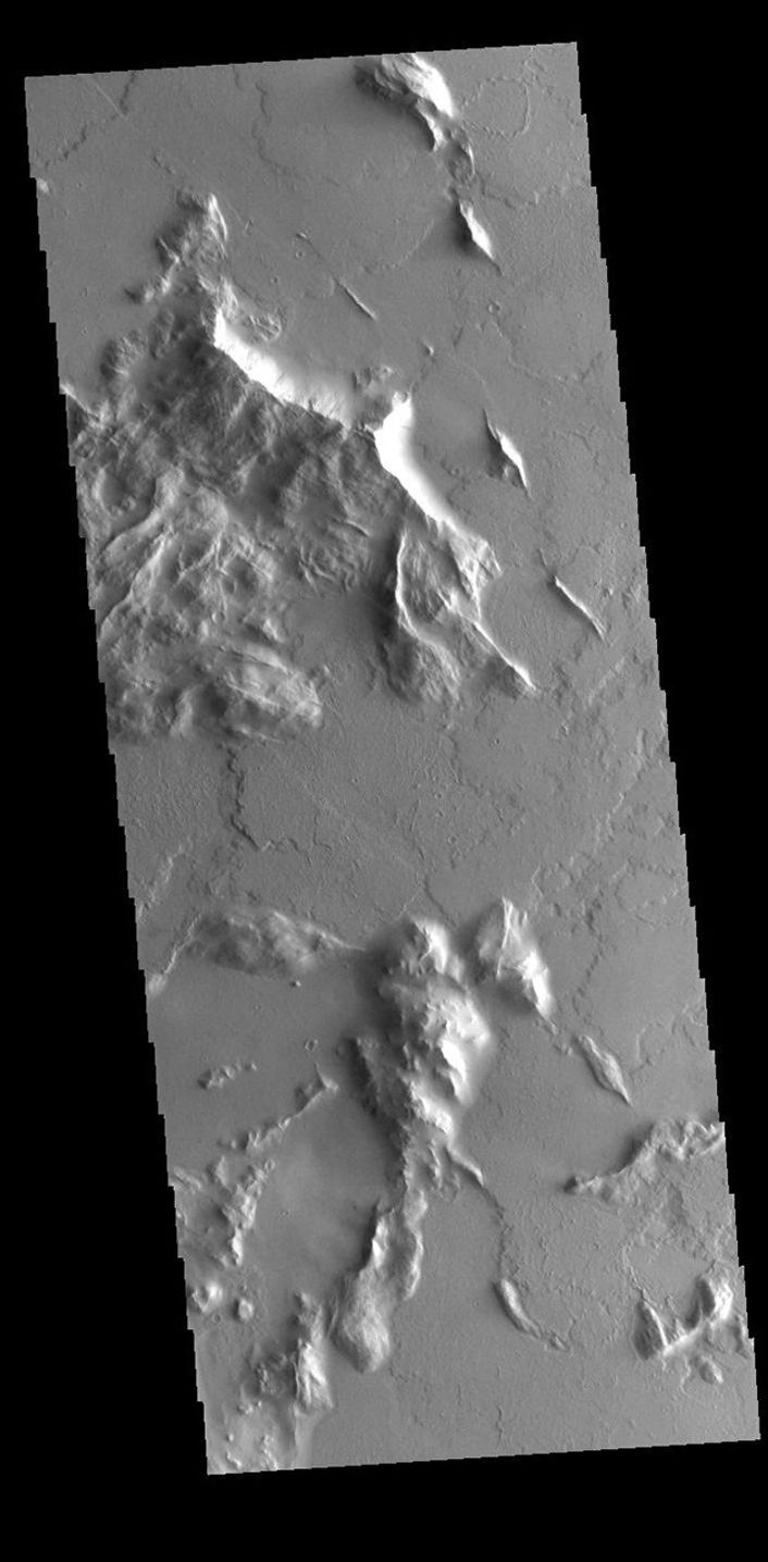 Located southwest of Olympus Mons, this image captured by NASA's 2001 Mars Odyssey spacecraft shows part of a complex region that has undergone several geologic processes.