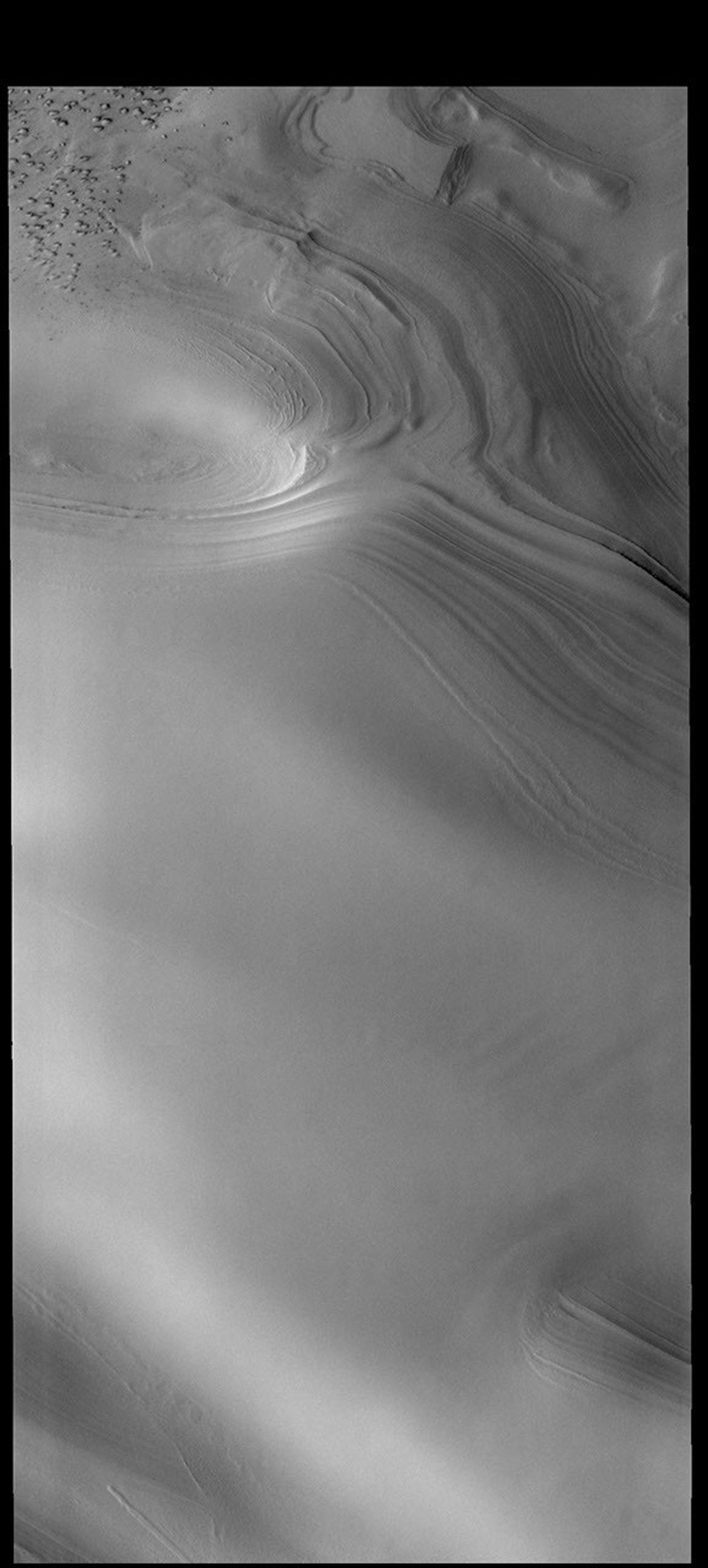 This image captured by NASA's 2001 Mars Odyssey spacecraft shows part of the margin of the north polar cap. Layering of the ice is visible in the top half of the image.