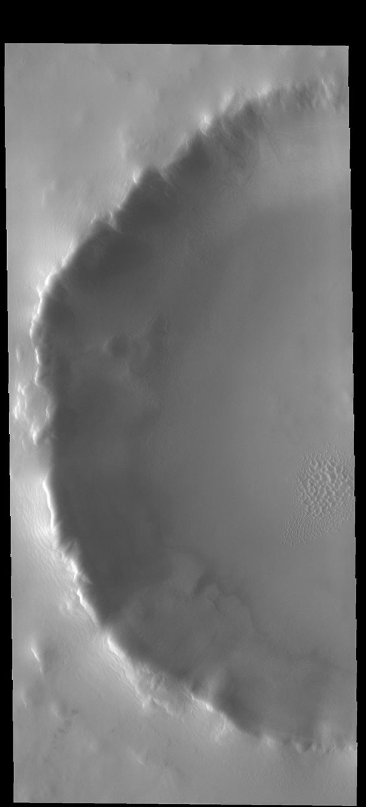 This unnamed crater contains a small dune field in the central part of its floor. This image from NASA's 2001 Mars Odyssey spacecraft was collected in northern spring and the dunes are still frost covered.
