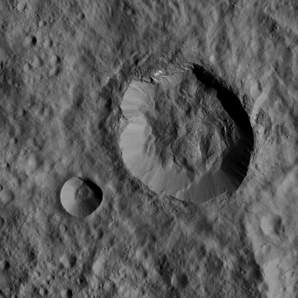 This image, taken by NASA's Dawn spacecraft on Jan. 1, 2016, shows two relatively young, fresh craters on Ceres. Large blocks of ejected material fell near the rims of the craters and onto the floor of the larger crater.