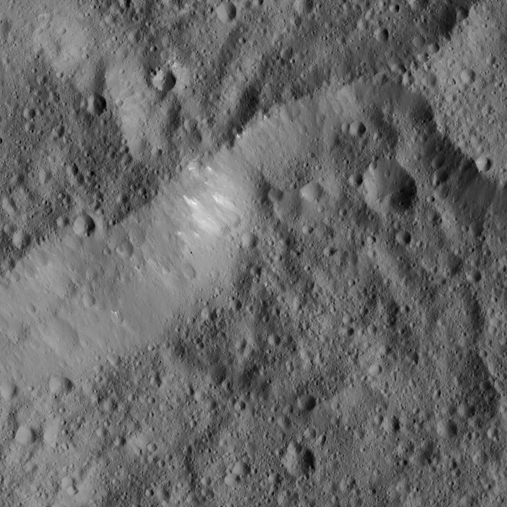 This scene from Ceres, captured by NASA's Dawn spacecraft, shows an older crater (at top center) that has been blanketed by impact ejecta from the younger crater to its right.