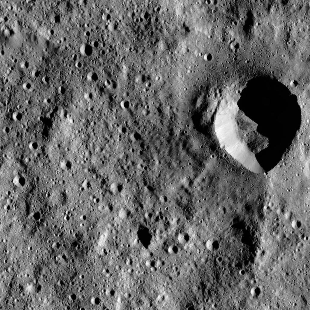 This image from NASA's Dawn spacecraft shows a fresh impact crater with an asymmetric rim. The crater displays a sharp rim over much of its perimeter that is interrupted by a smooth area in the north.