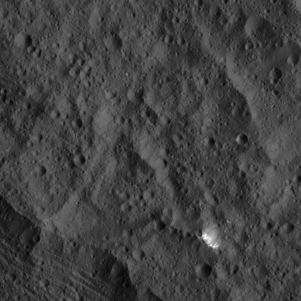 This image, taken by NASA's Dawn spacecraft, shows a small patch of bright material close to the northern rim of the giant crater Yalode, seen at lower left. Yalode is one of the largest impact basins on Ceres.
